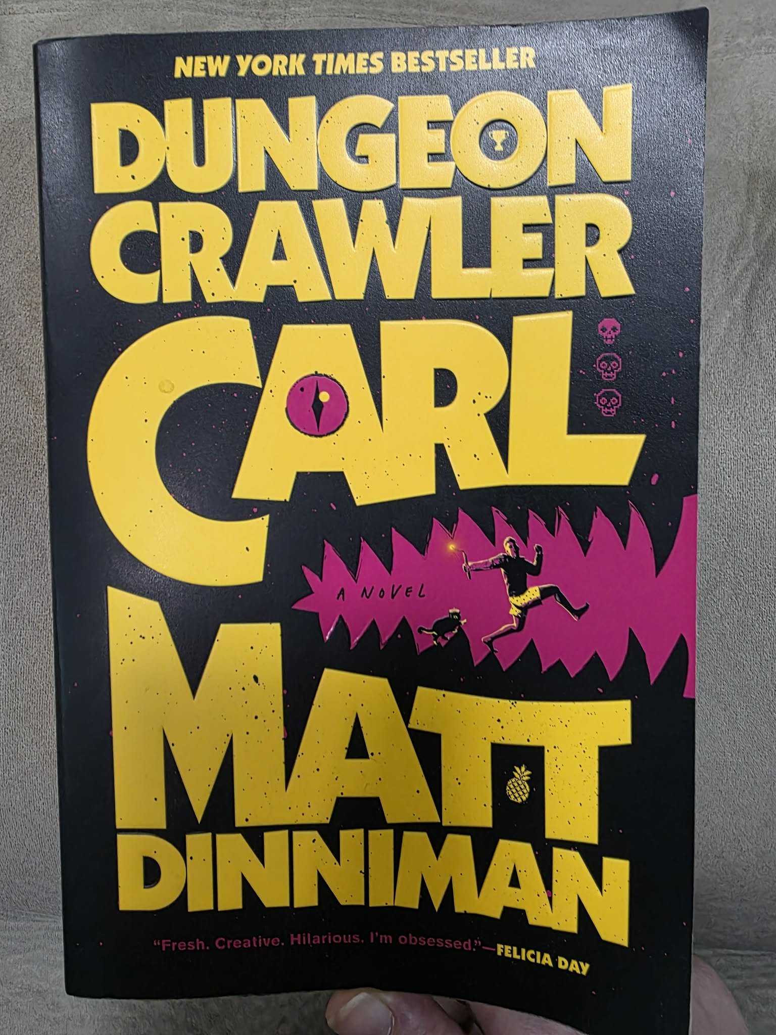 Novel cover Dungeon Crawler Carl by Matt Dinniman, featuring bold yellow font with a punchy purple sketch of Carl and Donut.