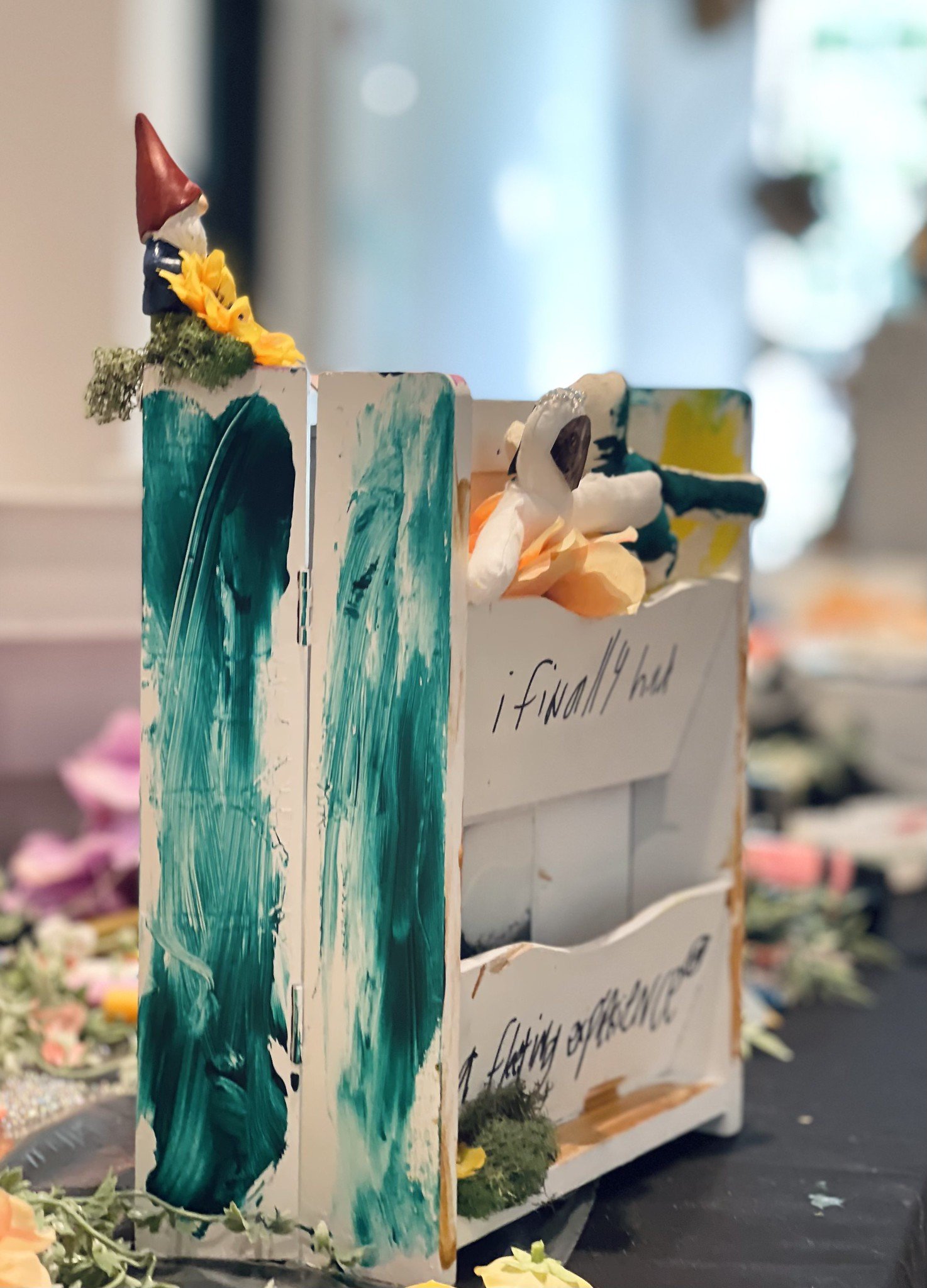 A documentation photo from Amanda Rose's Waystation Generation piece featuring a white piece with green paint, writing in black marker is visible