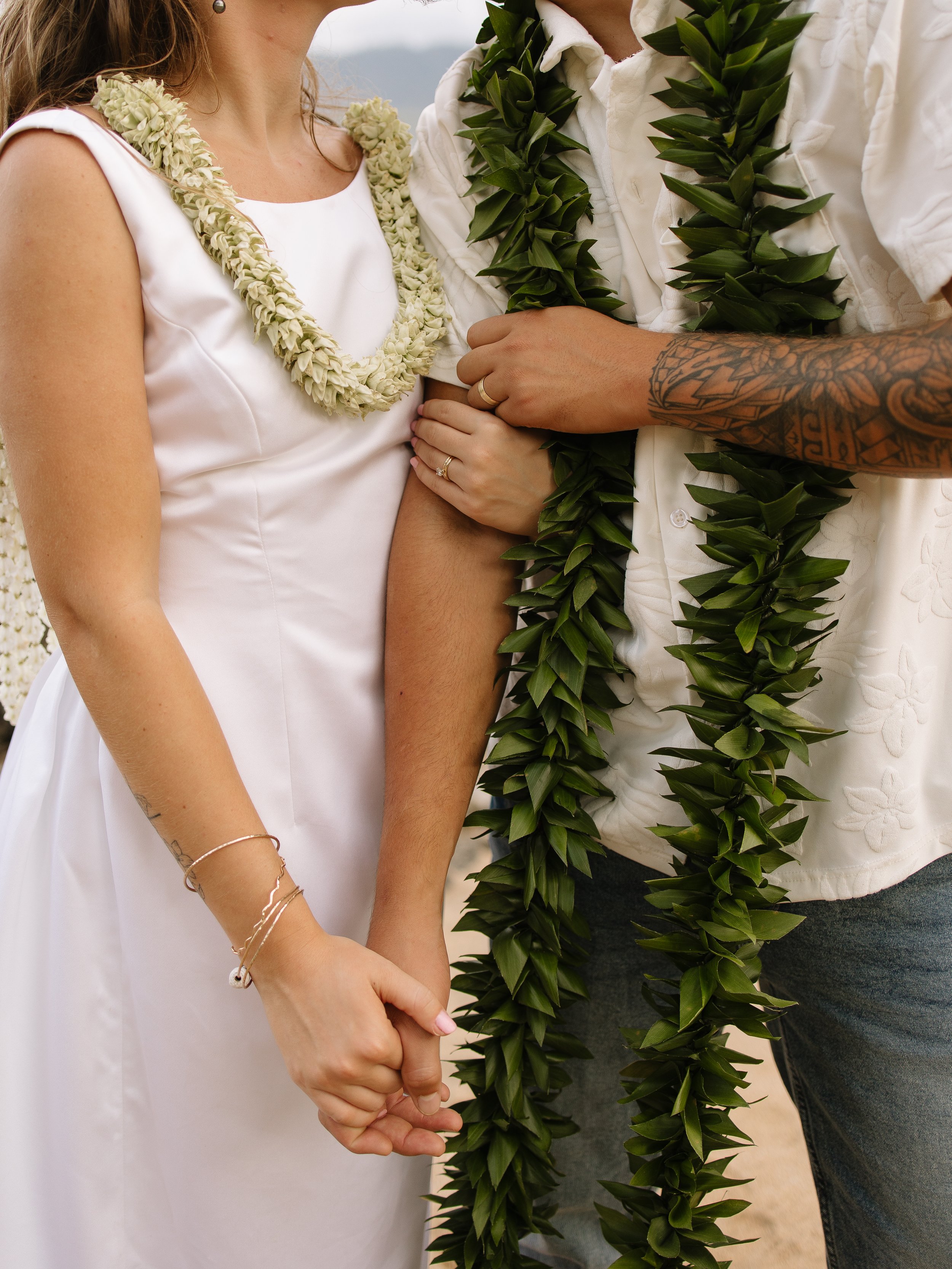 Outdoor wedding reception with bridesmaids and guests near a sign that reads "Jonah & Natalie" with scenic mountains and trees in the background.