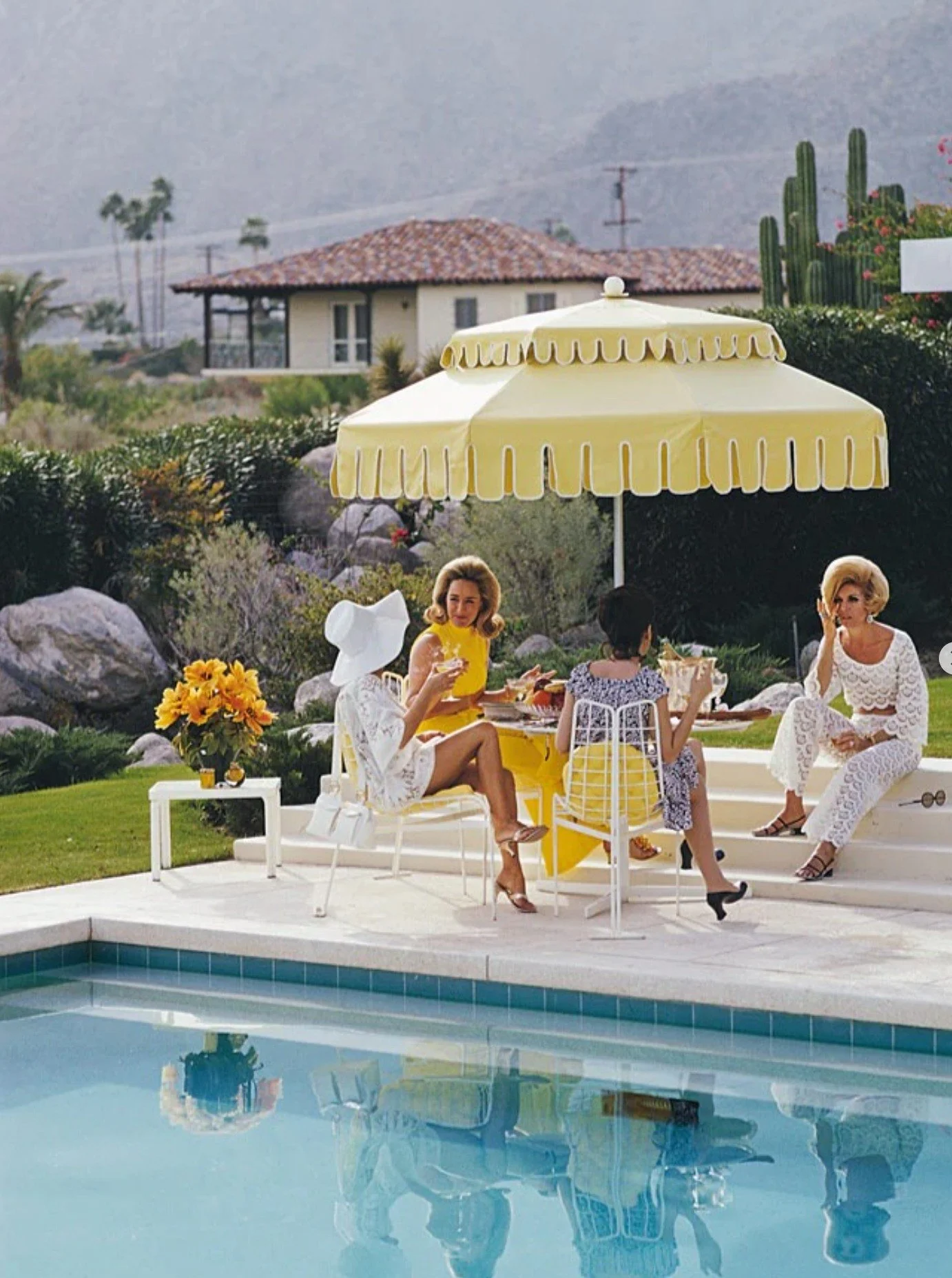 Ladies by the pool at the Kaufmann Desert House in Palm Springs, California, January 1970. From right to left, former fashion model Helen Dzo Dzo Kaptur (in white lace), unknown, Nelda Linsk (in yellow), wife of art dealer Joseph Linsk, and actress L