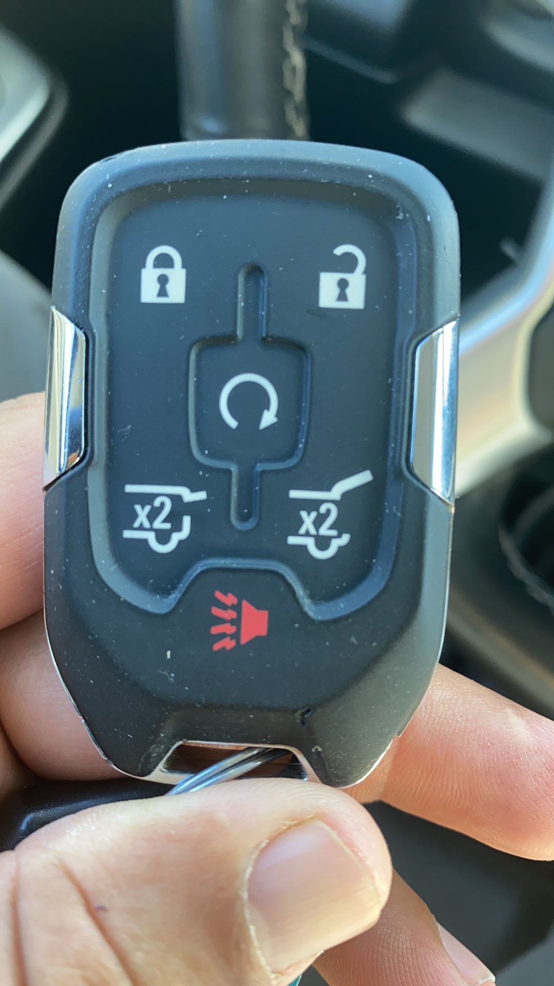 Close-up of a car key fob showing lock, unlock, trunk, and panic buttons.