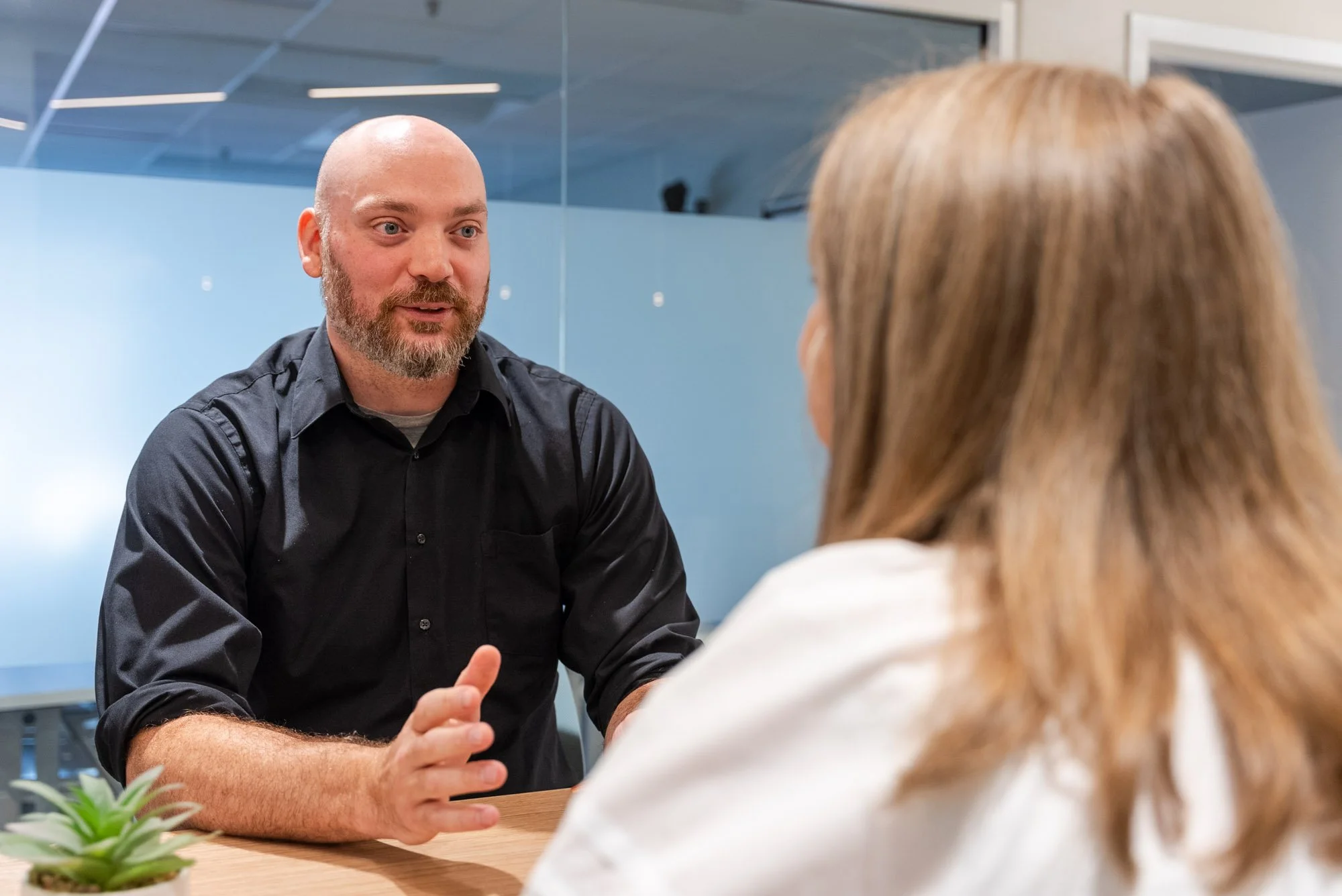 friendly man in professional office setting talking to a woman