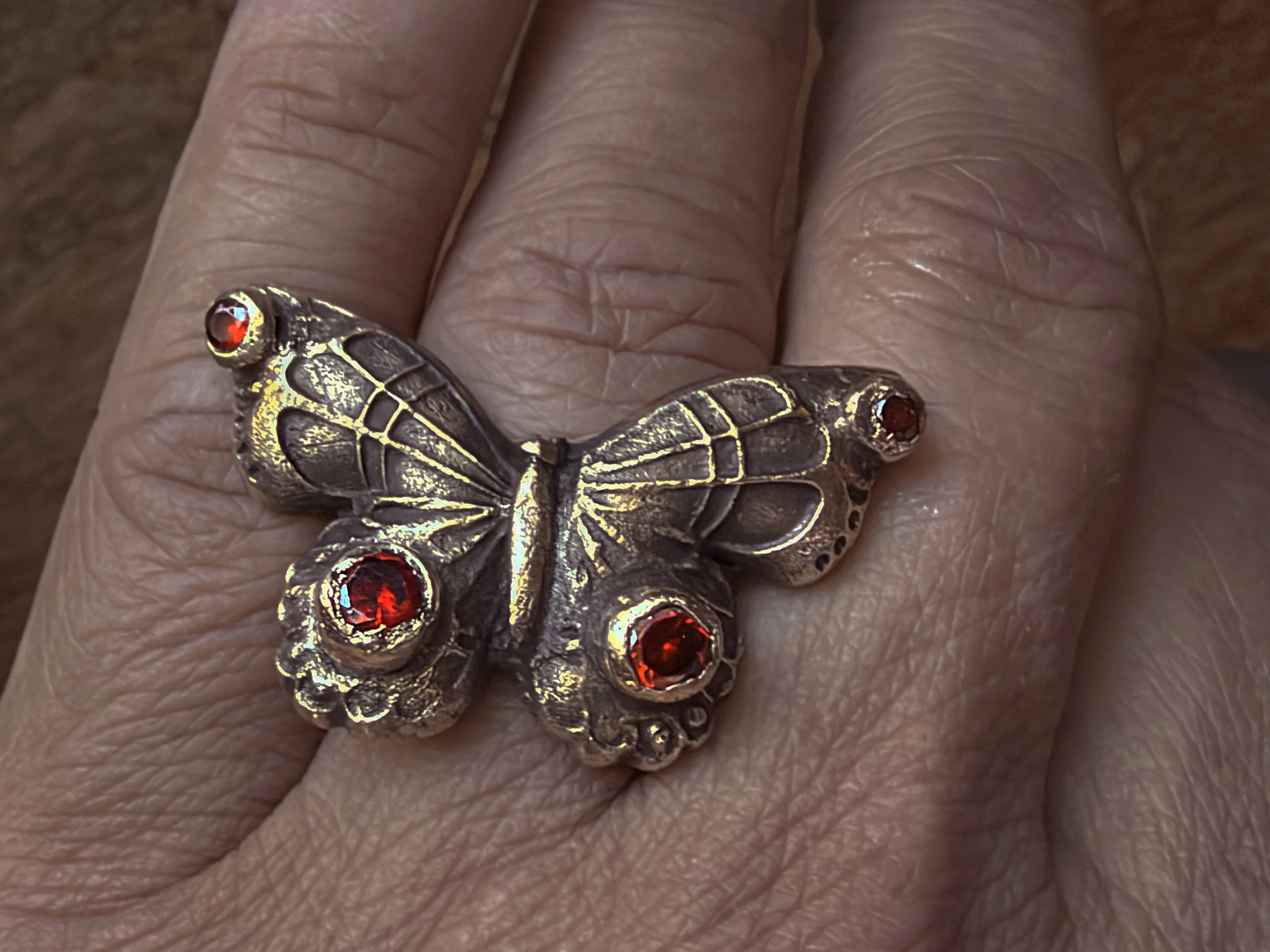 dolly-butterfly-ring-bronze-fire-gemstone-red-worn-overhead-birdley-studio.jpg