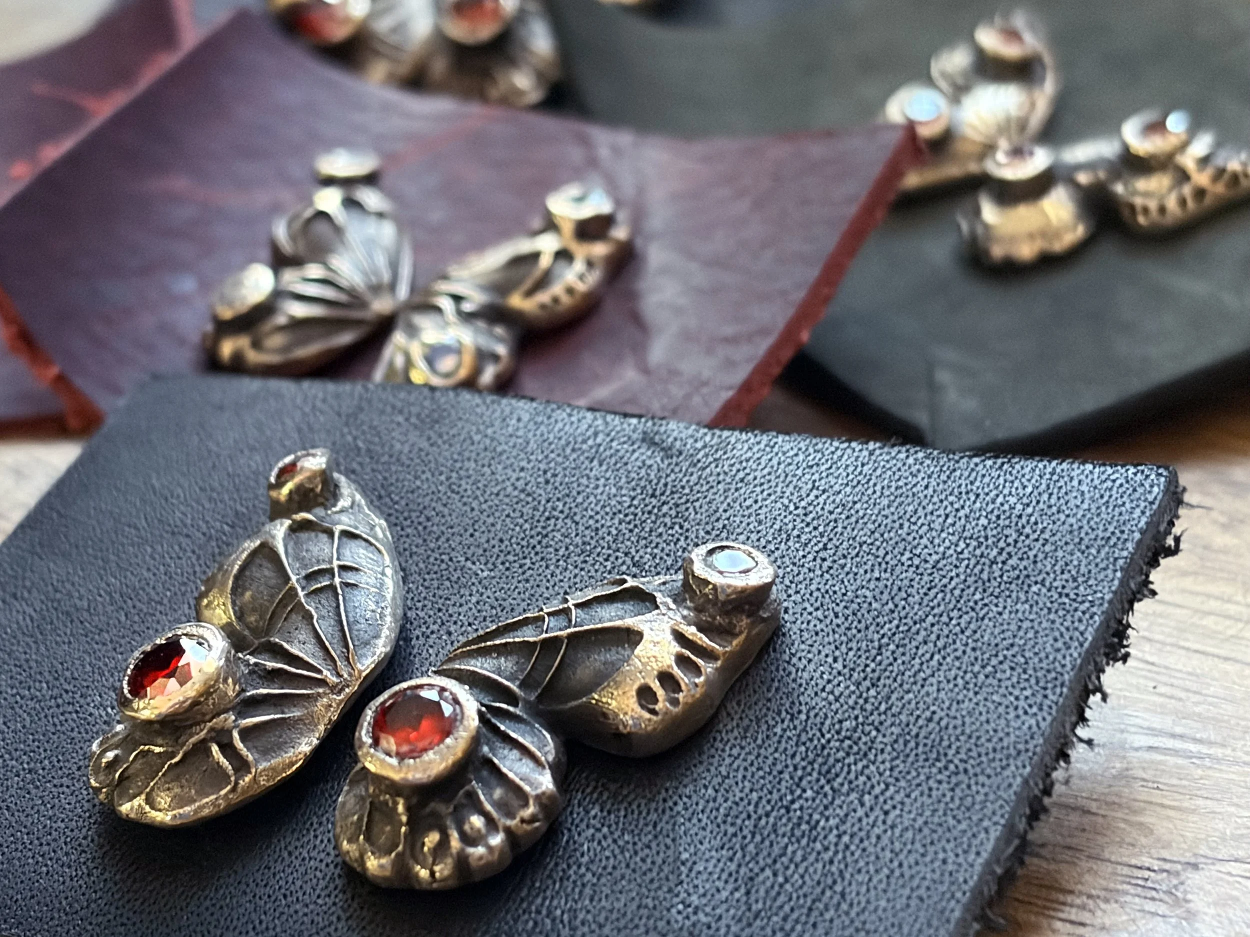 dolly-butterfly-stud-earrings-bronze-large-red-gemstone-group-overhead-birdlet-studio.jpg