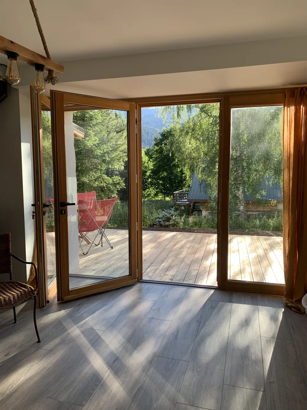 Le séjour du gîte, portes-fenêtres grandes ouvertes sur la terrasse