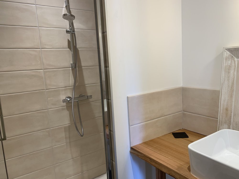 Salle d'eau beige de l'étage, douche à l'italienne et vasque sur plan de bois