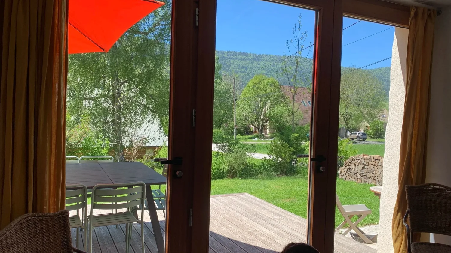 Vue sur le jardin et les montagnes du Vercors depuis le séjour du gîte