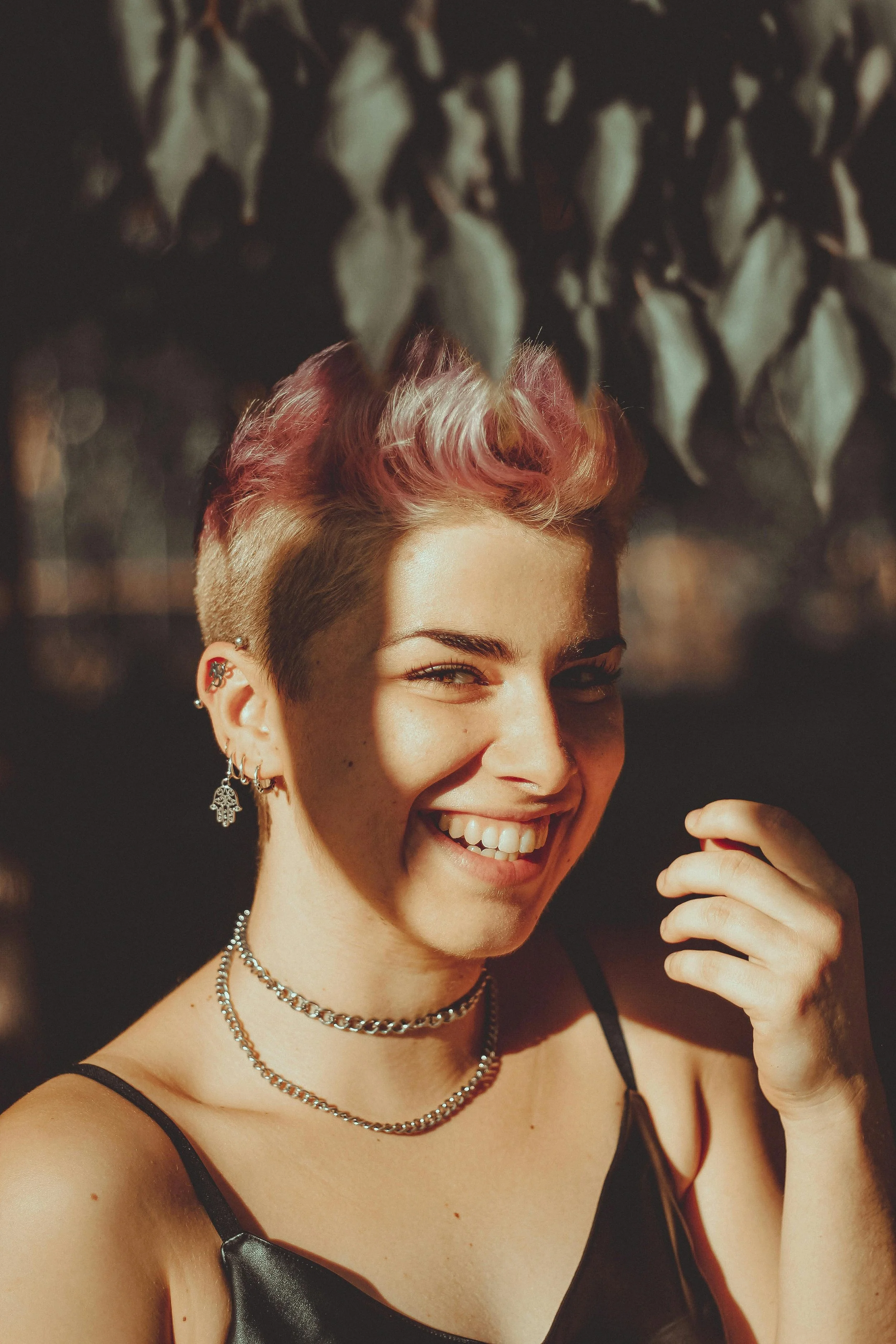 person with short pink hair smiling