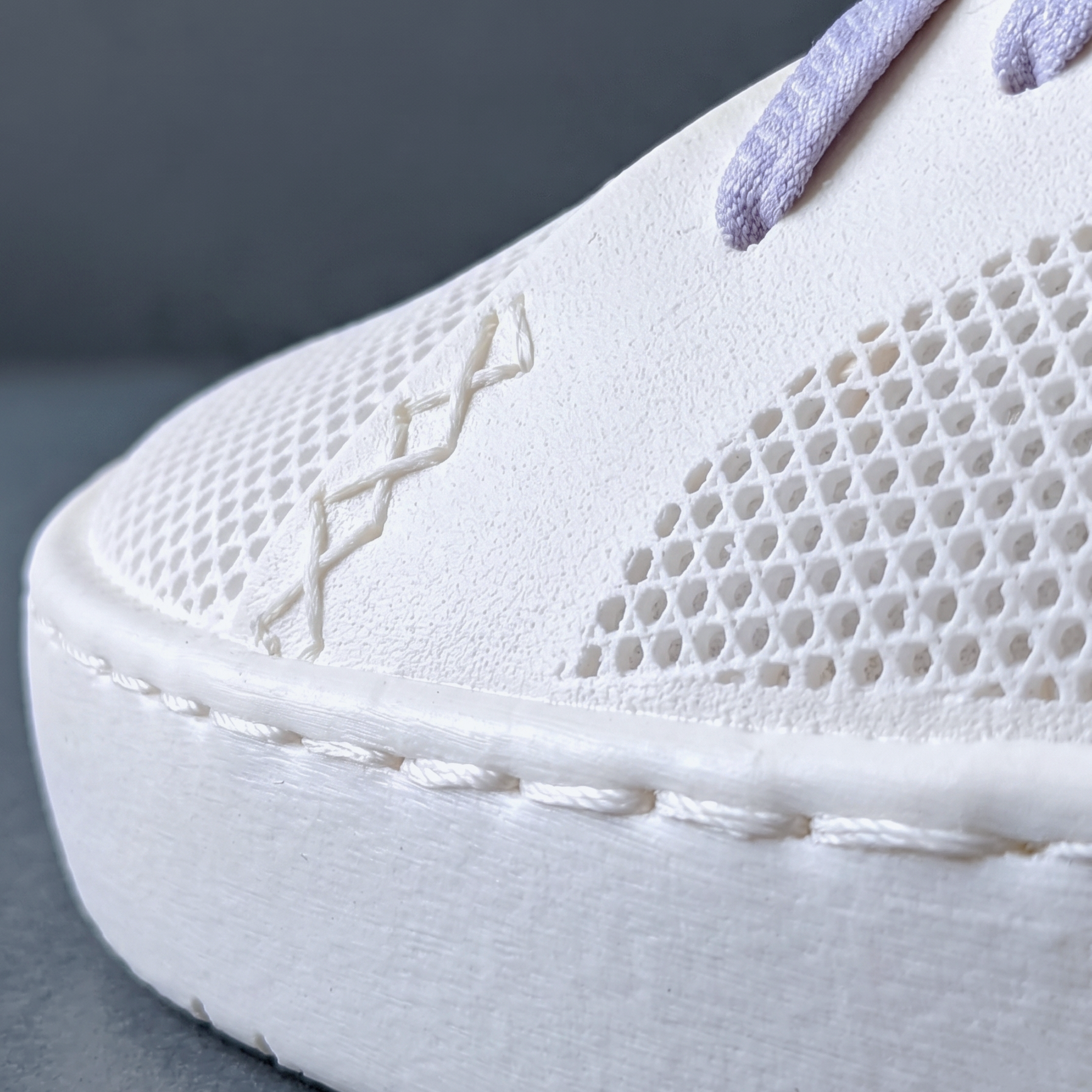 Close-up of a white METIS shoe showing glue-free EasyStitch details. A fully circular footwear platform for sustainable brands and boutiques.