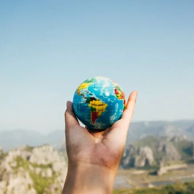 Hand holding a small globe, representing WAZP’s green supply chain and carbon footprint reduction