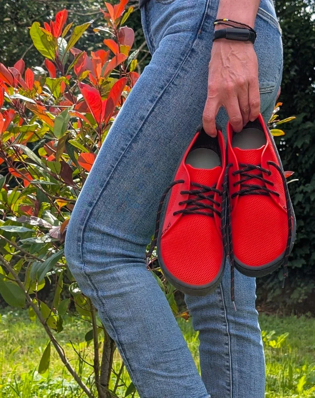 Person holding red METIS 3D printed modular sneakers outdoors — custom-branded sustainable footwear available for on-demand production partnerships
