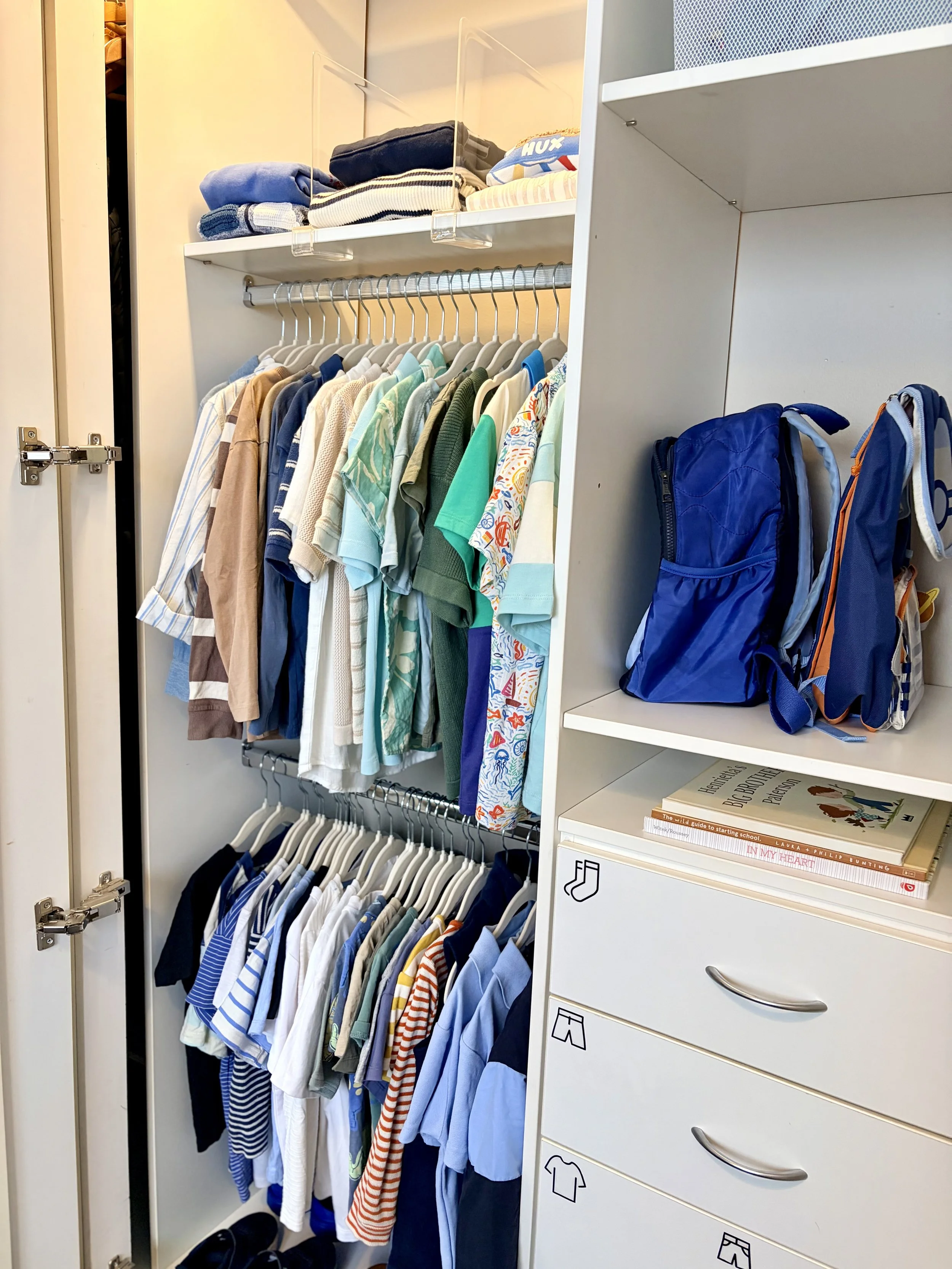 A timber bunk bed in a tidy and organised children's Bedroom with lots of storage compartments for the toys.