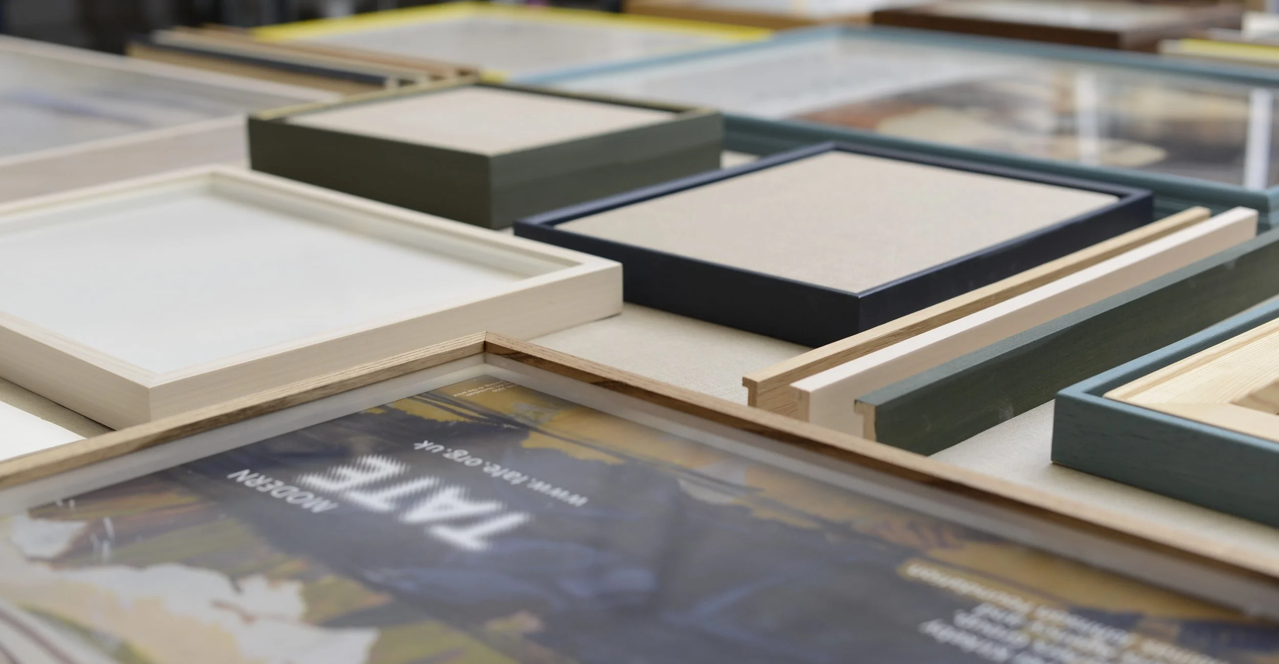 Various picture frames in different shapes, sizes, and colors displayed on a surface.