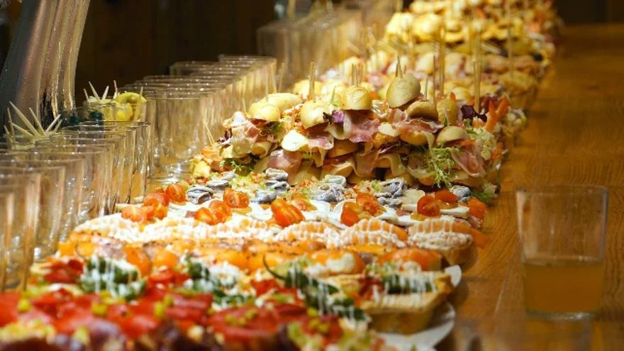 Table filled with a variety of colorful pintxos in San Sebastián, showcasing an assortment of bite-sized Basque tapas with fresh ingredients and creative toppings.