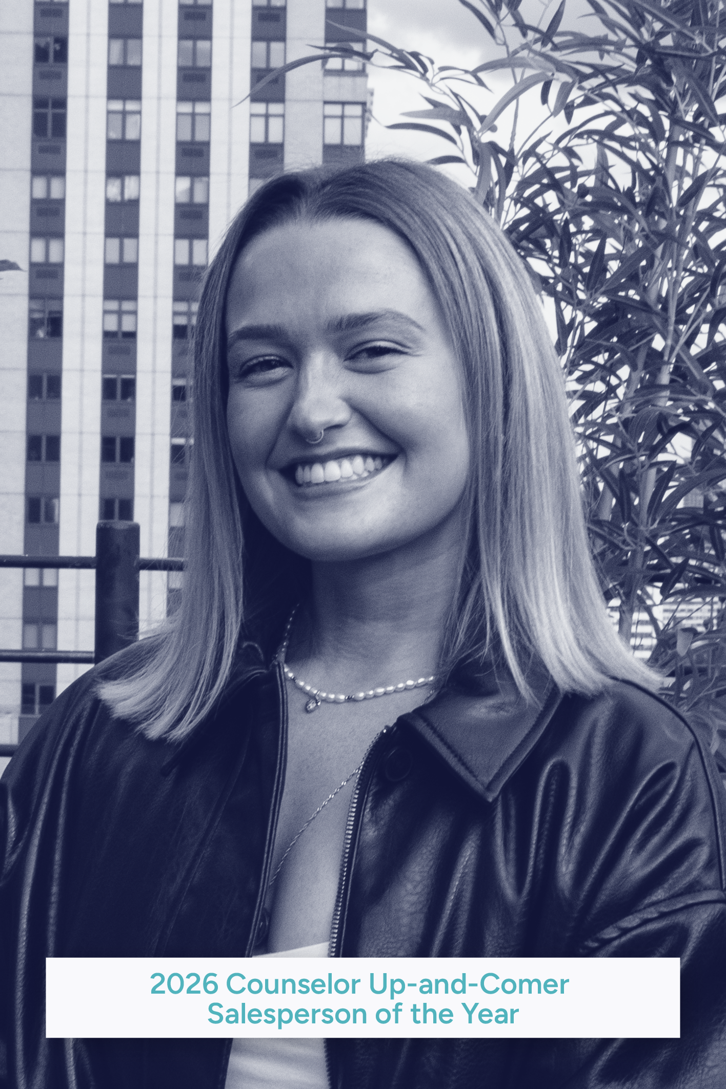 A woman with long hair, wearing a leather jacket, smiling, standing outdoors with city skyscrapers and trees in the background.