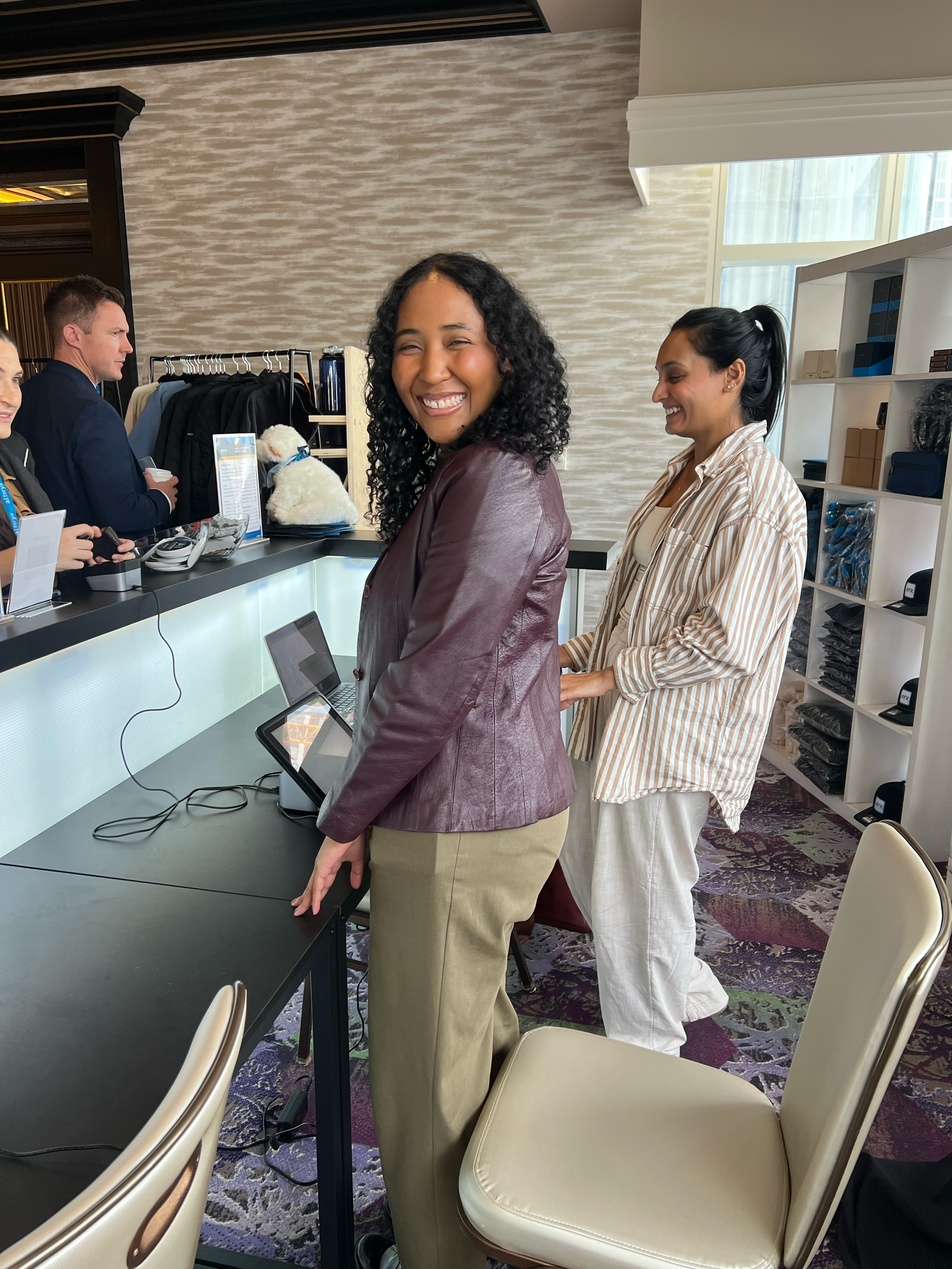 Whitestone team members managing an end-to-end brand activation booth for the Alteryx RKO corporate event featuring custom event signage, organized apparel merchandise racks, shelving displays, and point-of-sale digital setup.