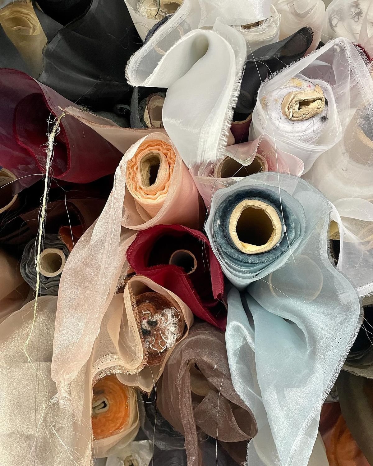 Rolls of deadstock material in various colors to be repurposed into new garments.