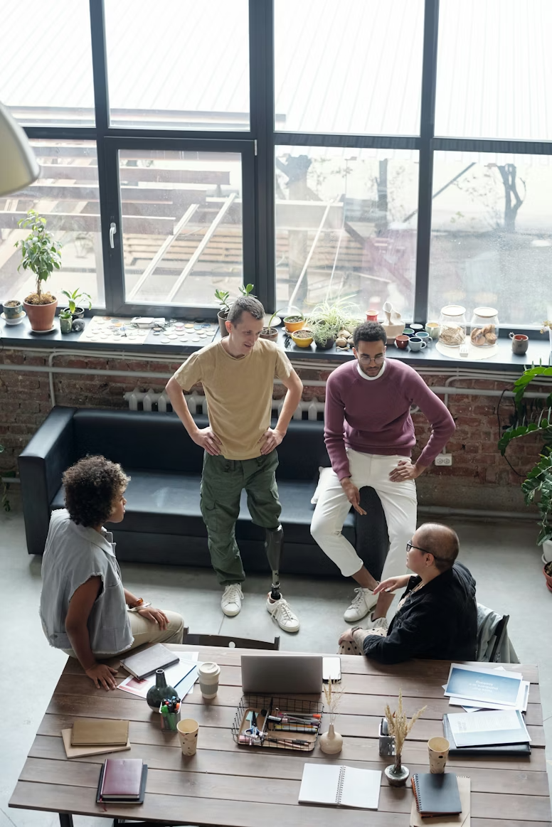 Group of workers gathered around a desk conversing, emphasizing the hands-on planning that an onsite activation can take.