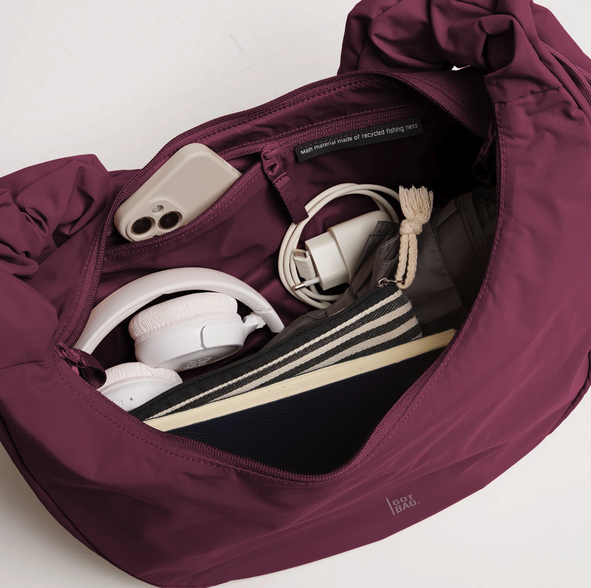 Burgundy GOT BAG travel backpack with organized storage compartments, water-resistant recycled material, and minimalist branding for work, travel, and everyday carry.