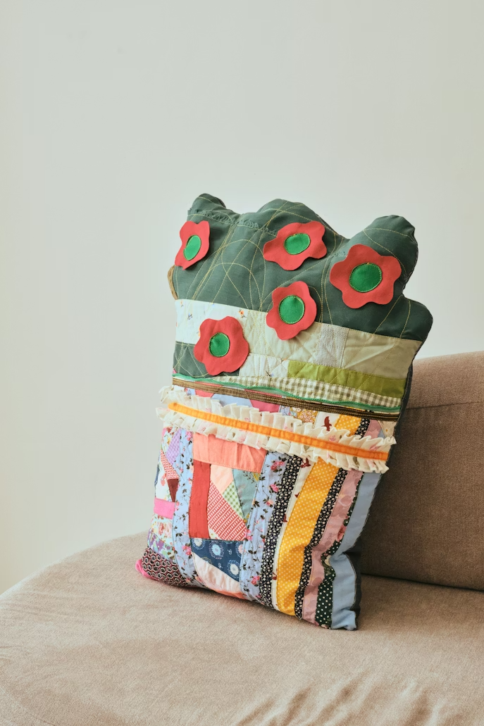 Appliqué decoration showing cut fabric piece stitched onto garment or bag base creating layered dimensional retail decoration