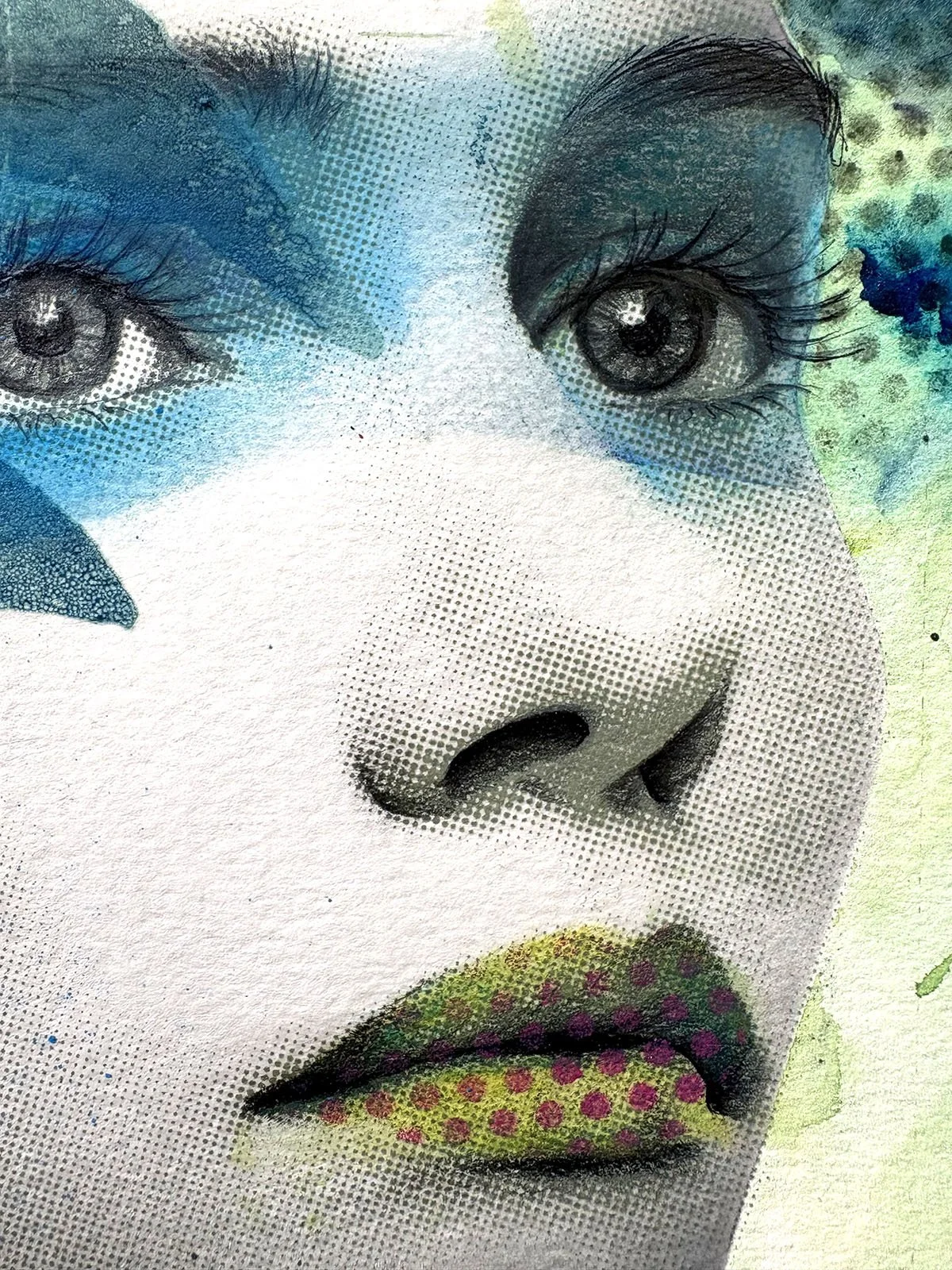 Close-up of a portrait of a woman with artistic makeup, including blue eyeshadow, black eyeliner, detailed eyelashes, and lips with multicolored polka dots.