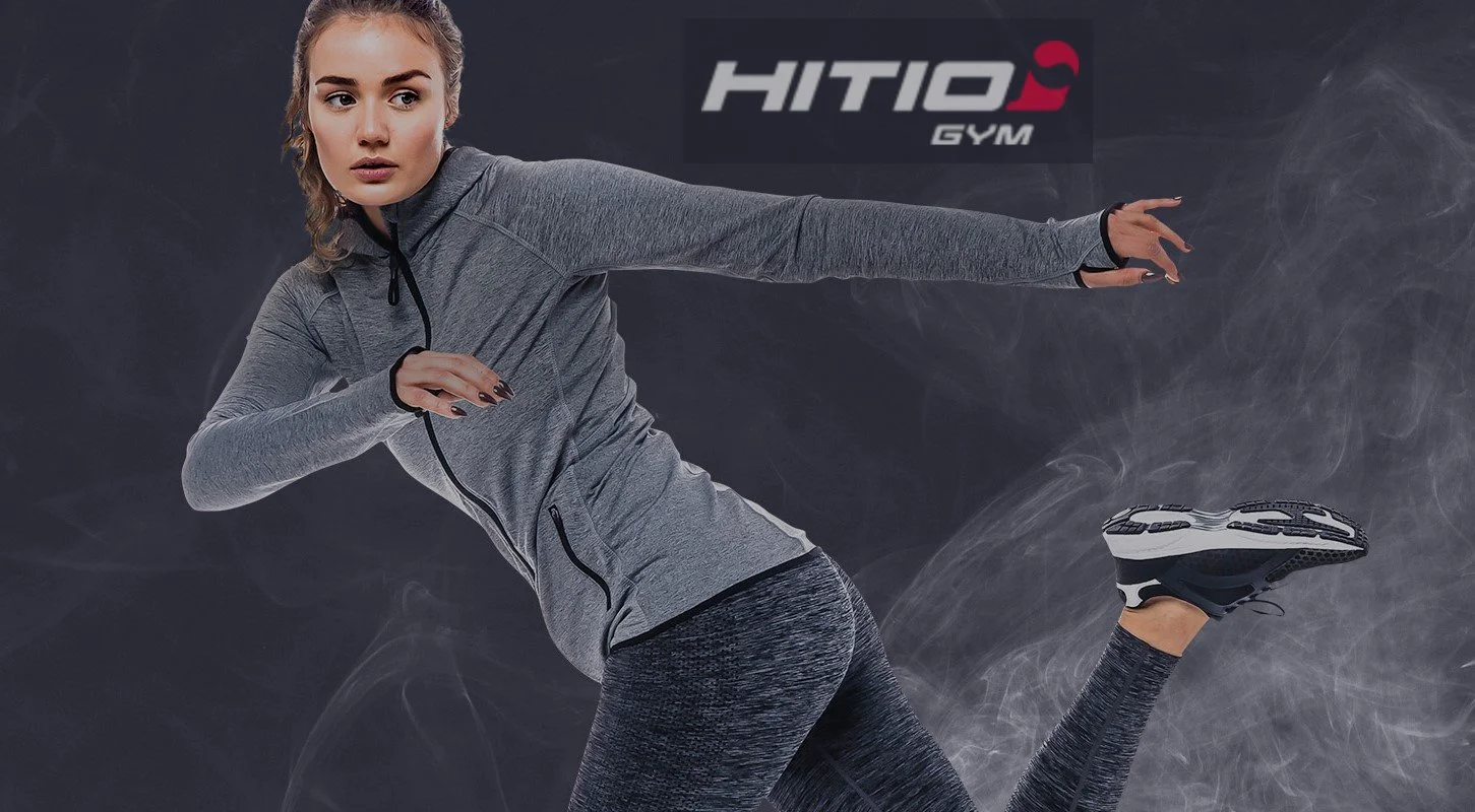 A woman in gray athletic wear poses as if running or sprinting, with a dark background and a logo reading 'HITIO GYM' in the upper right corner.