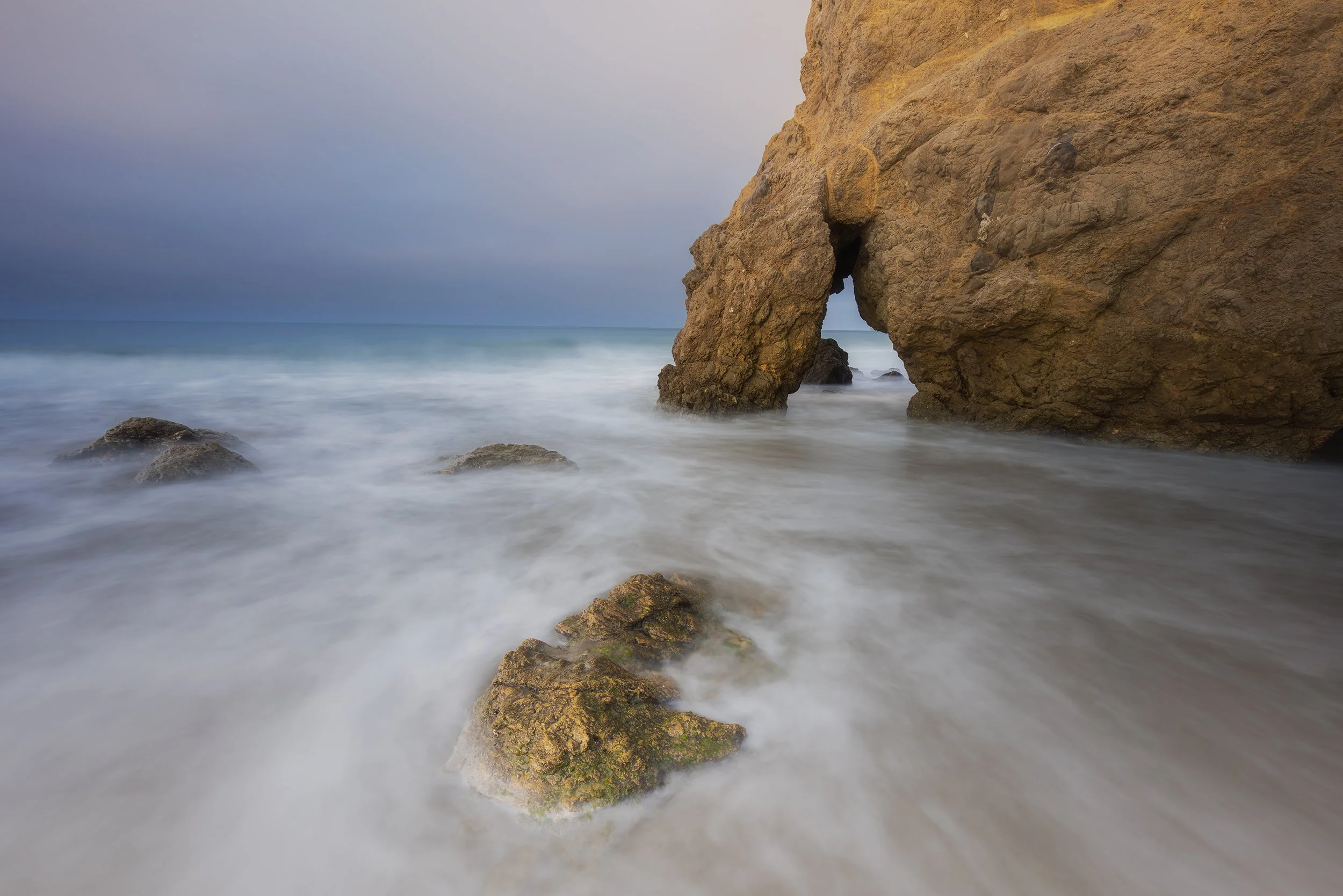 A long exposure image of the rocky coast along the Pacific Ocean at El Matador State Beach in Malibu, California