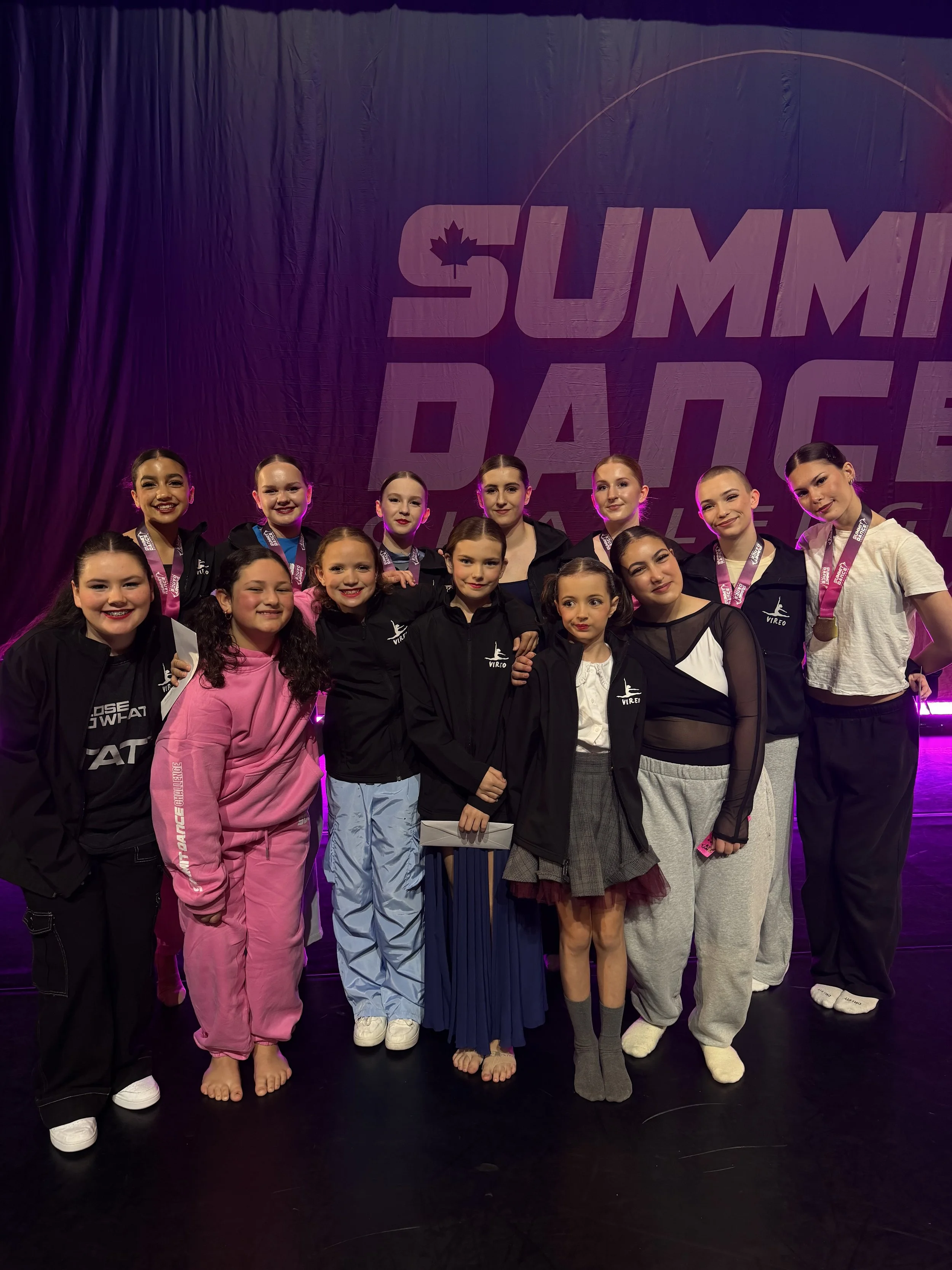 a group of young female dancers on stage at a competition.  