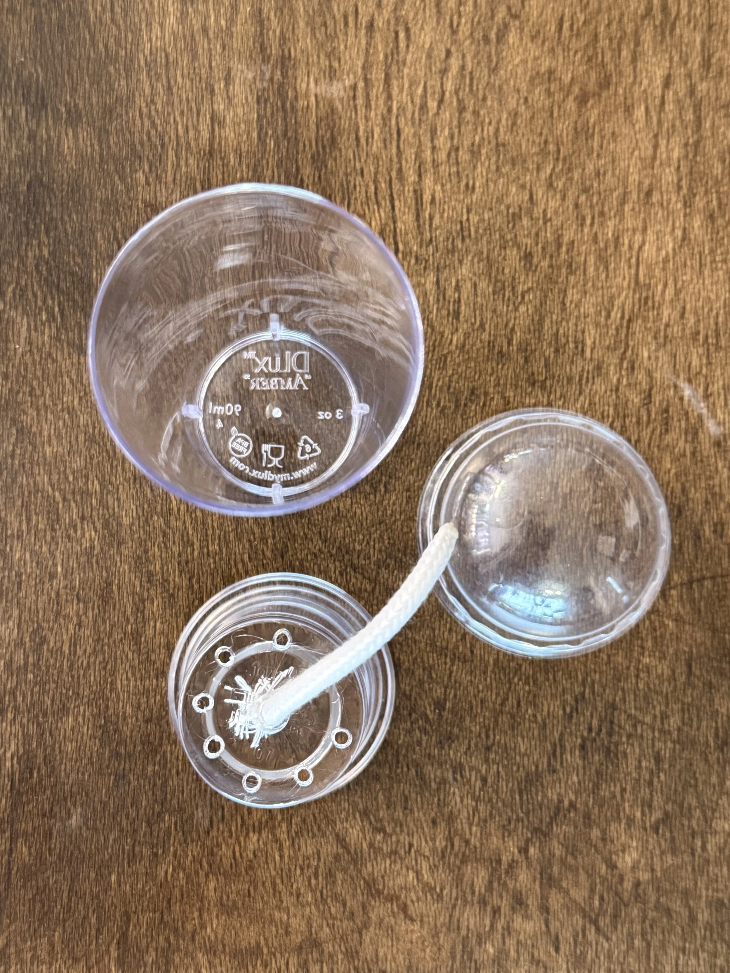 Disassembled self-watering corm cup showing inner cup, reservoir, wick, and dome