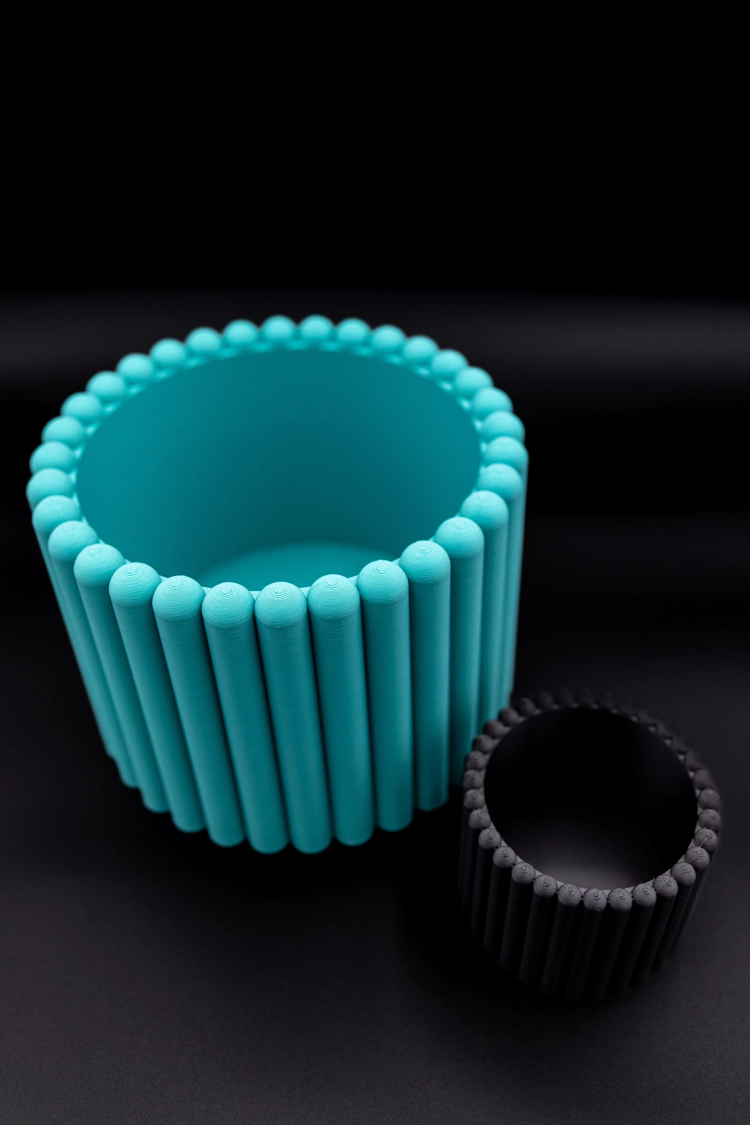 Overhead view of teal and black Carlie Planters showing interior shape.