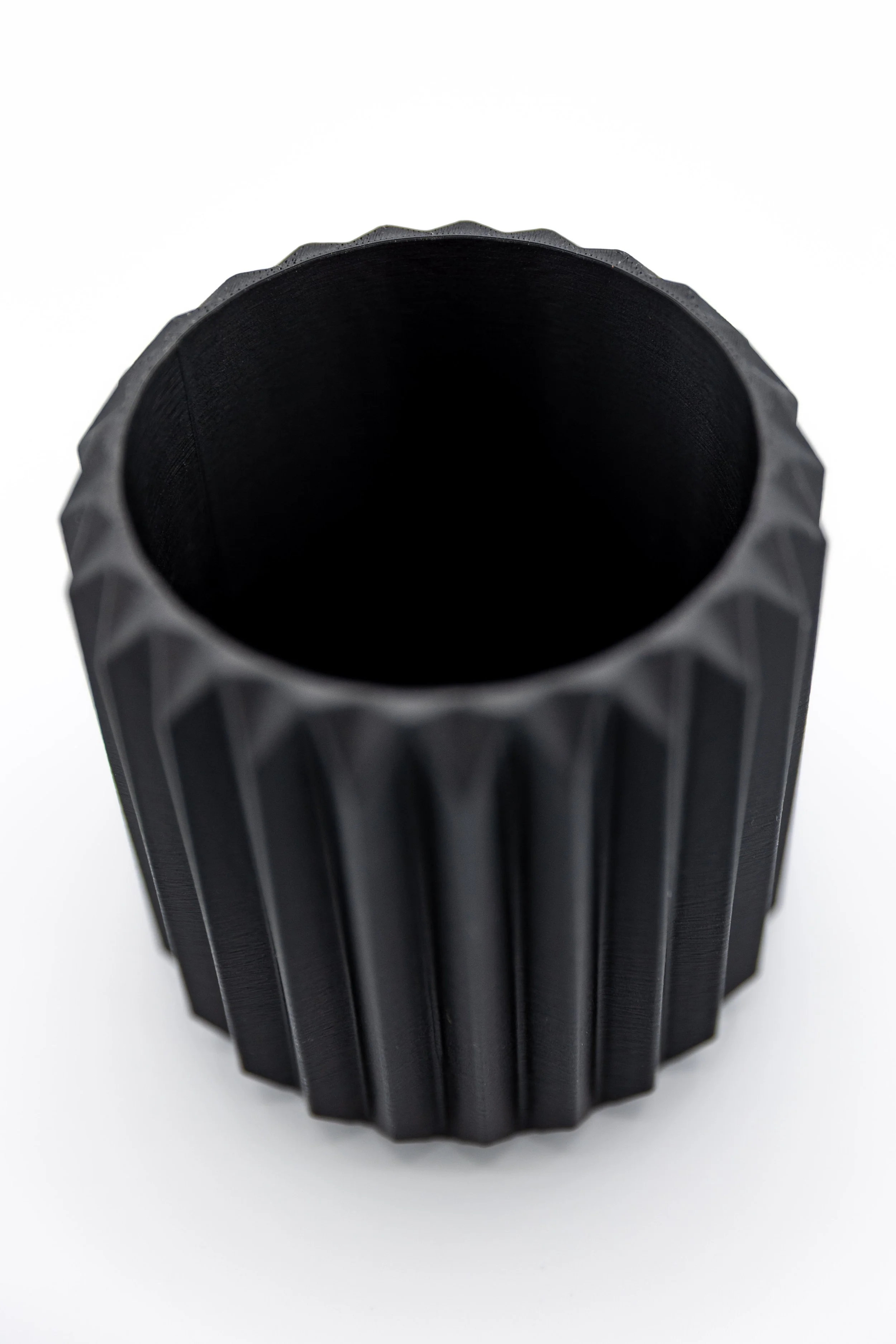 Empty black Myla Planter with vertical ridged texture on a white background.
