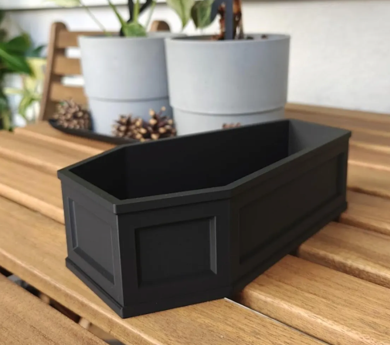Rear three-quarter view of empty coffin planter showing rectangular paneling and sturdy base.