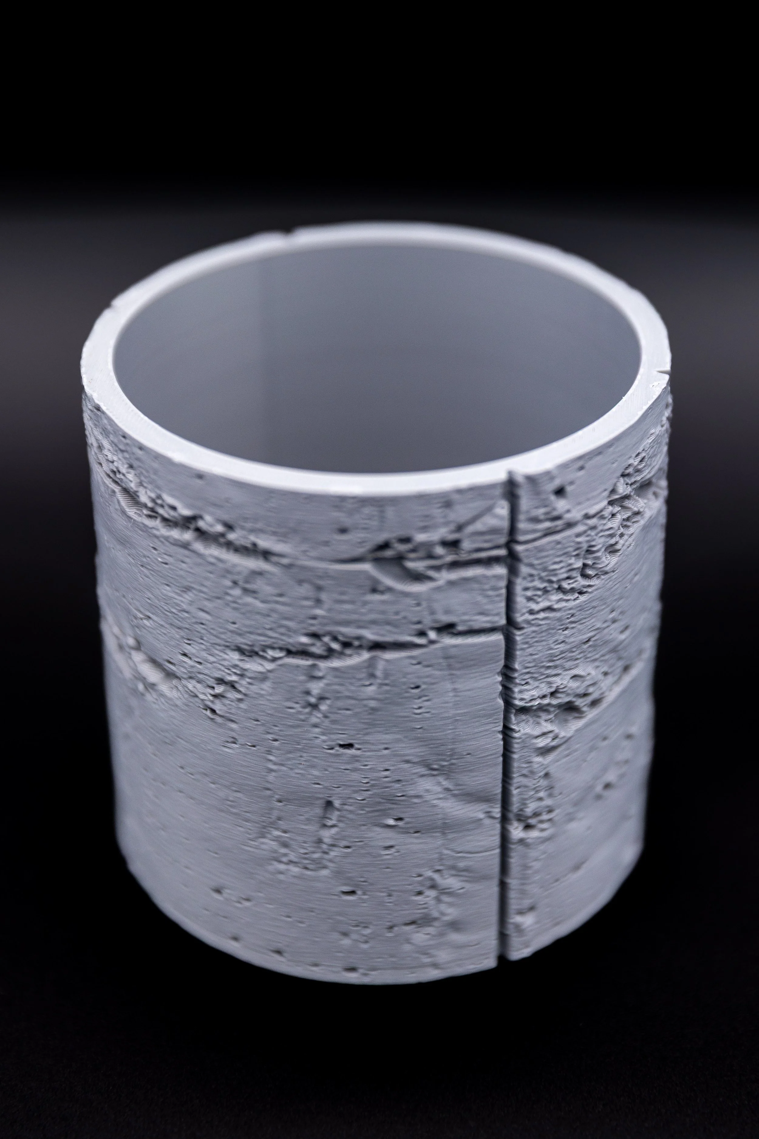 Empty Concrete Jungle Planter on black background showing full exterior weathered texture.