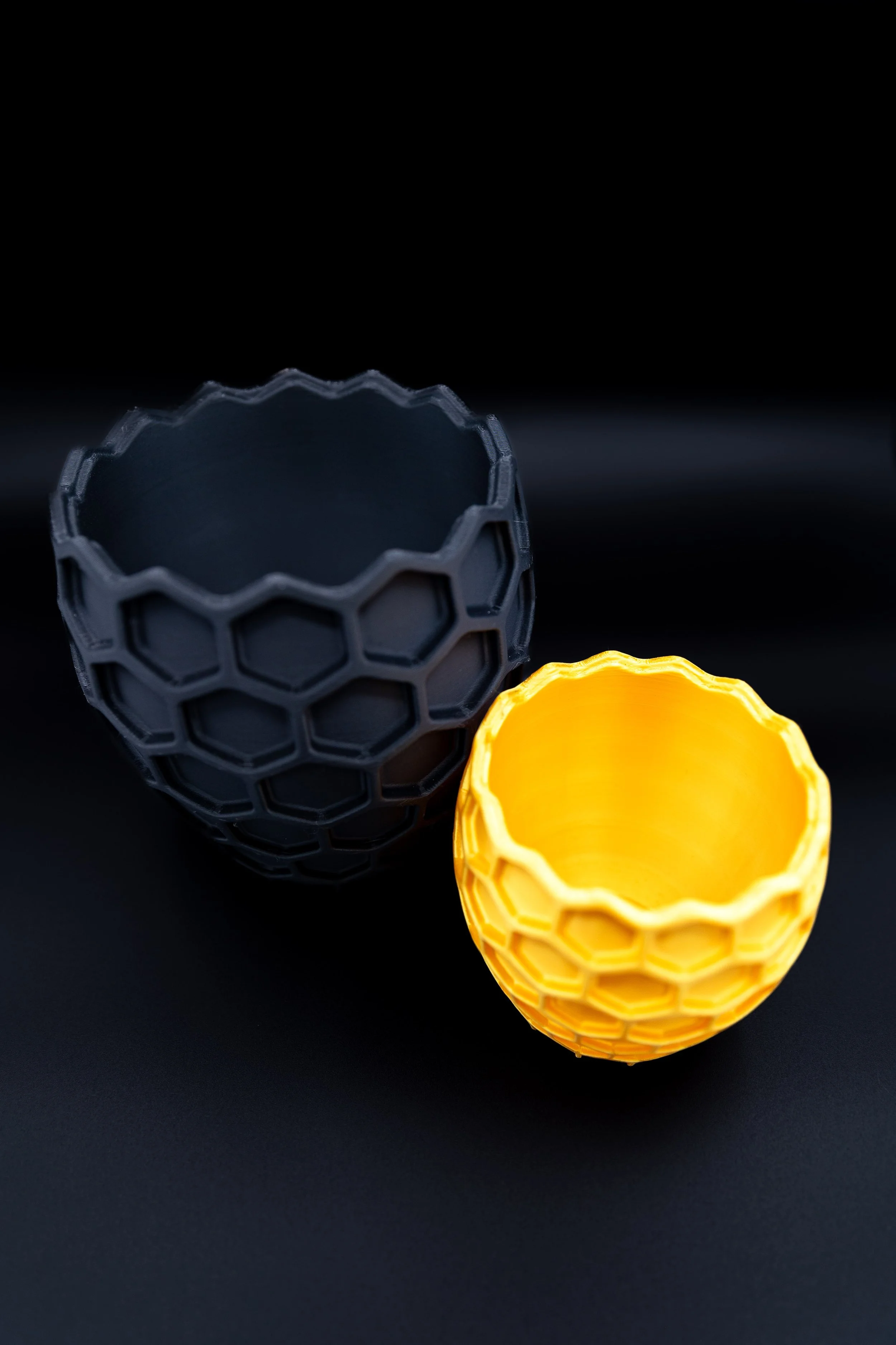 Black and yellow Bees Knees Planters displayed empty on a dark background.