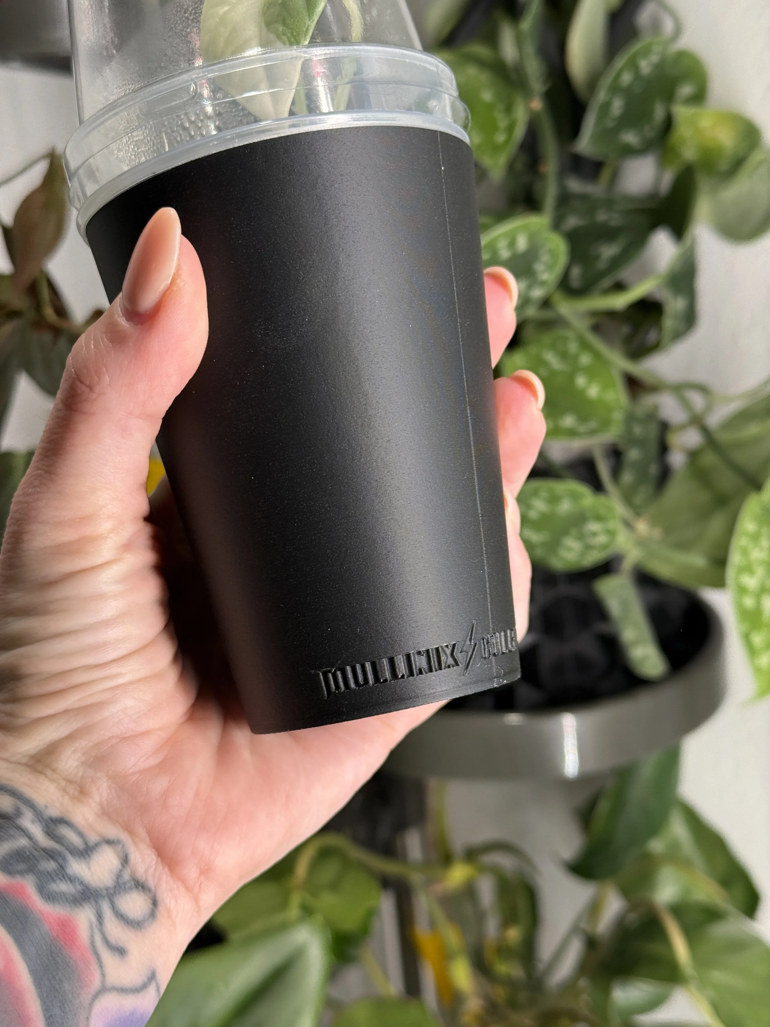 Close-up of black 9 oz cover cup showing Mullinix Collective logo detail and matte texture