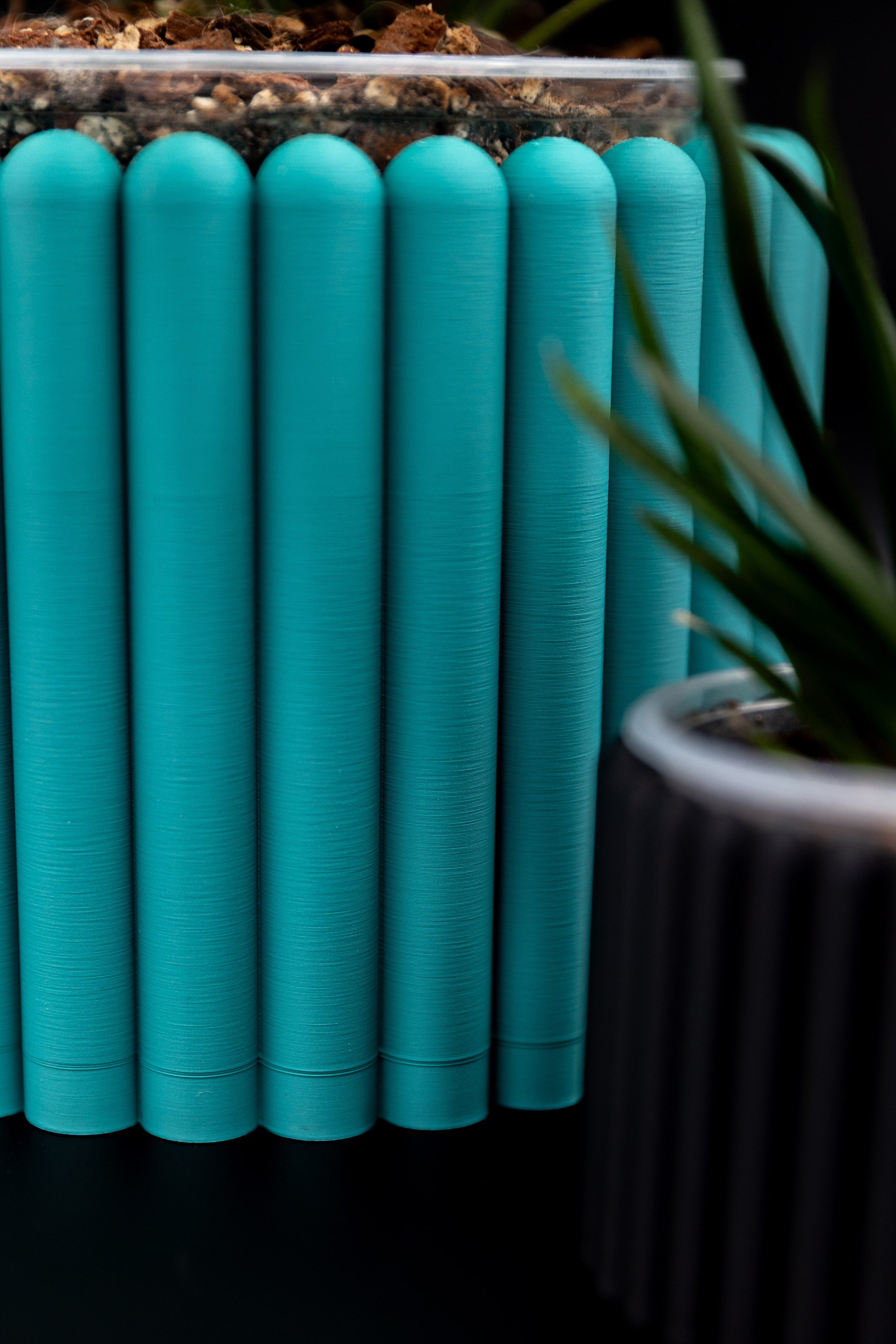 Macro shot of the teal Carlie Planter’s ribbed surface.