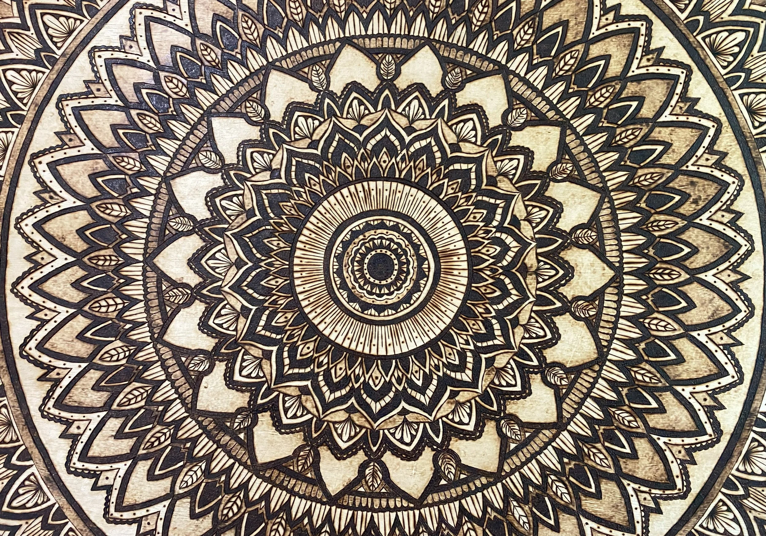 A detailed, symmetrical mandala design with concentric circles featuring intricate patterns in black and beige tones.