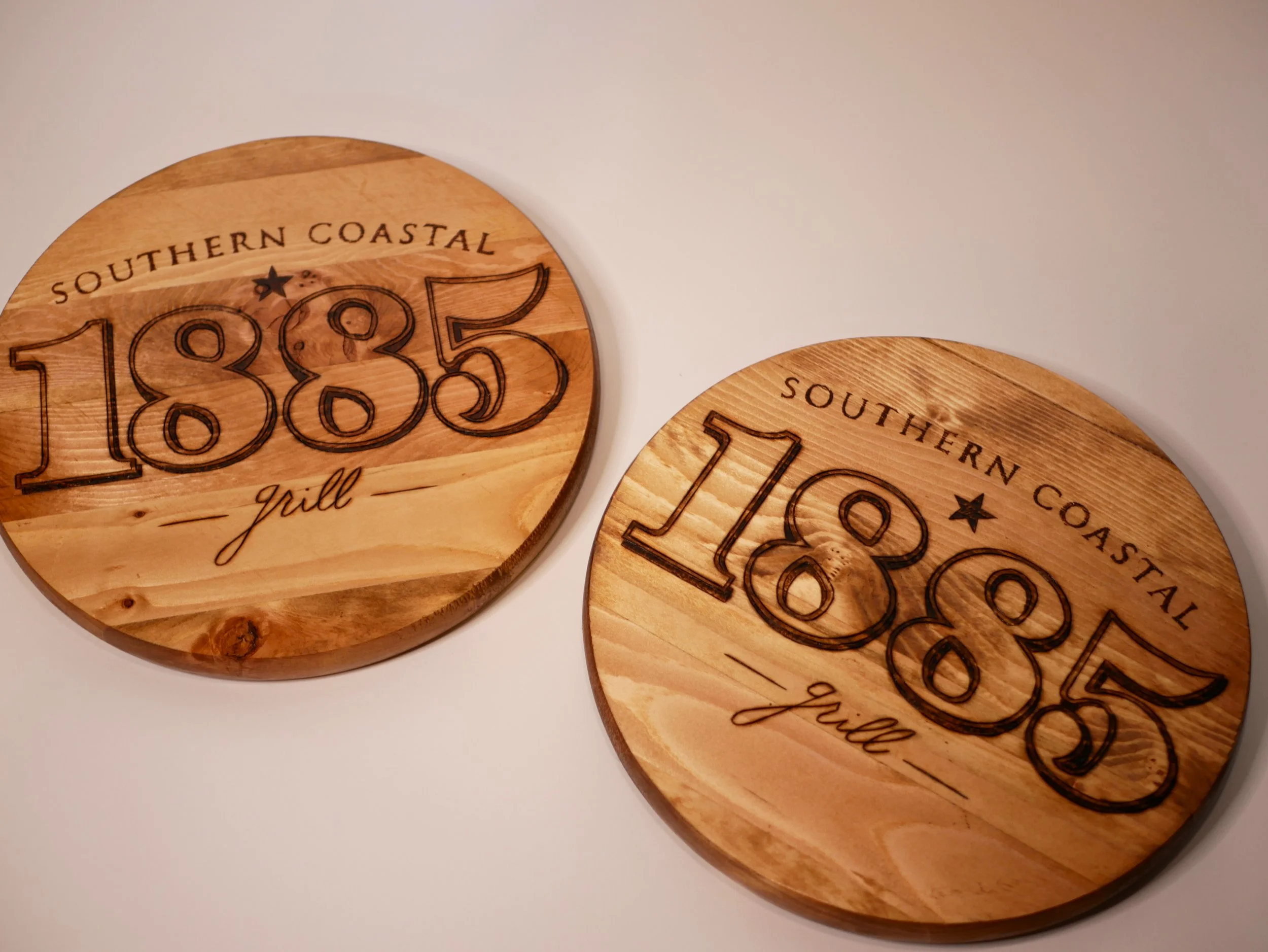 Round wooden plaques engraved with 'Southern Coastal 1885 Grill' 
