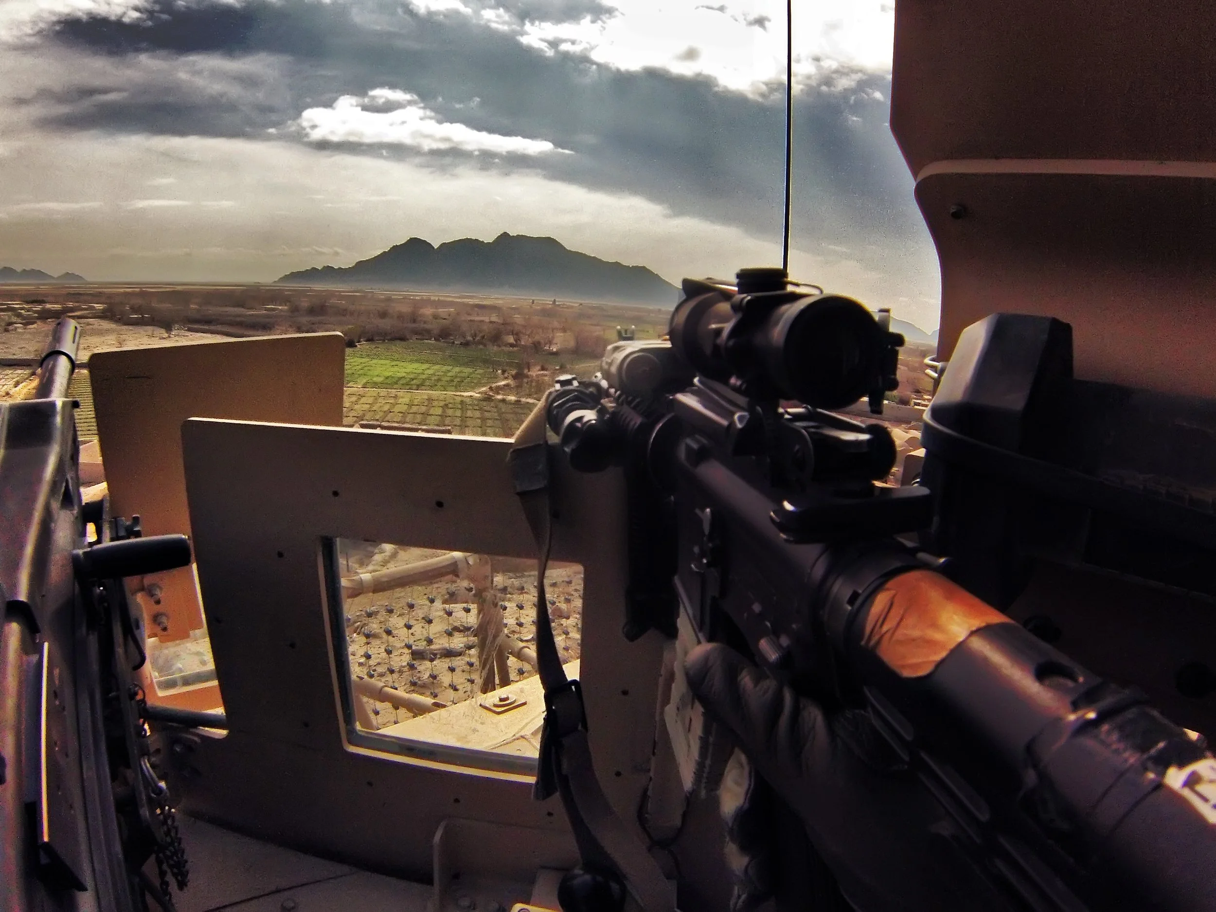 Spc. Matthew Zalewski holds his M4 Rifle, with a Mk19 Grenade Launcher mounted to a MATV while Afghan National Army (ANA) fight the Taliban below 3 Tank Hill in Nejat, Panjwai Afghanistan 2013. 