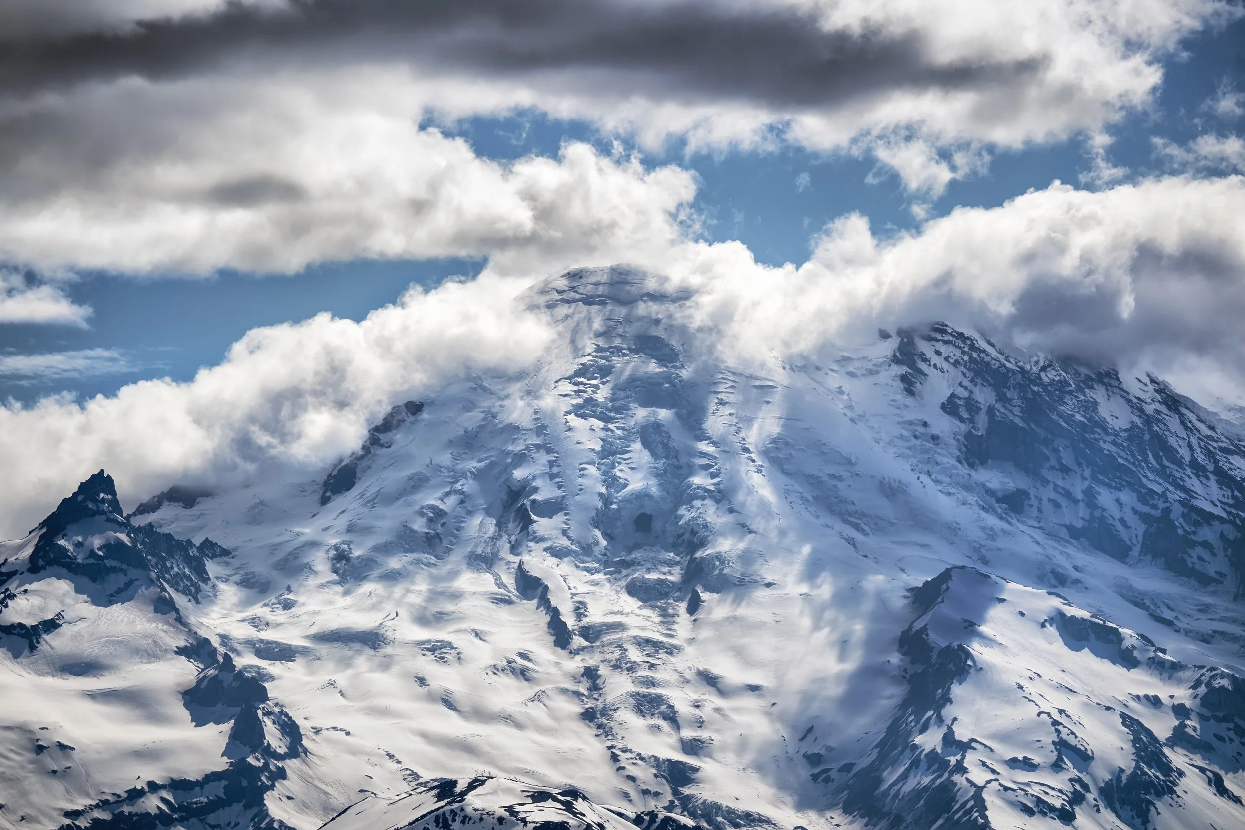 Snow-covered mountain peak with clouds in the sky
