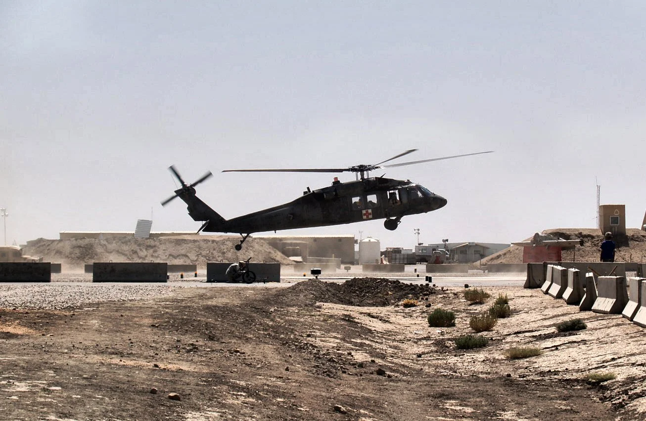 A DUSTOFF UH60 Blackbird Helicopter conducting a MEDIVAC lands at the Combat Support Hospital at Tallil AFB Iraq. They would subsequently unload a wounded soldier who was struck by an IED June 2006. 