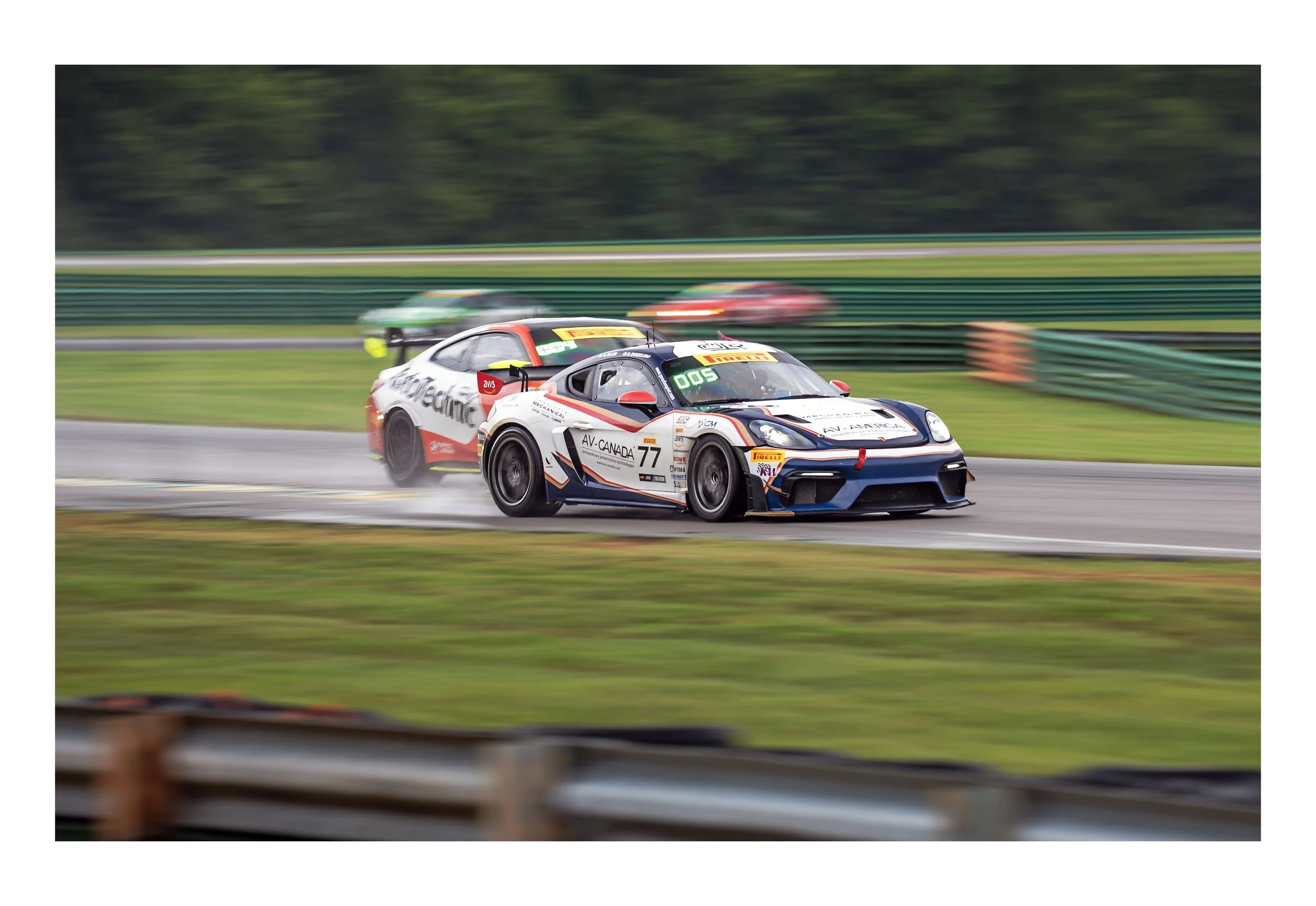 A race car speeding on a track with motion blur, surrounded by green barriers and trees in the background.