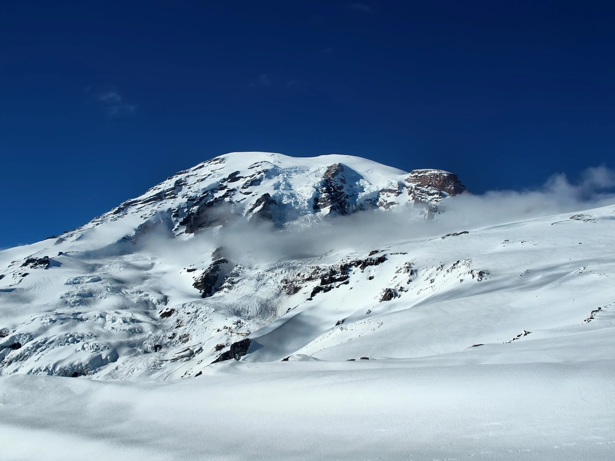 Snow-covered mountain peak under a clear blue sky.
