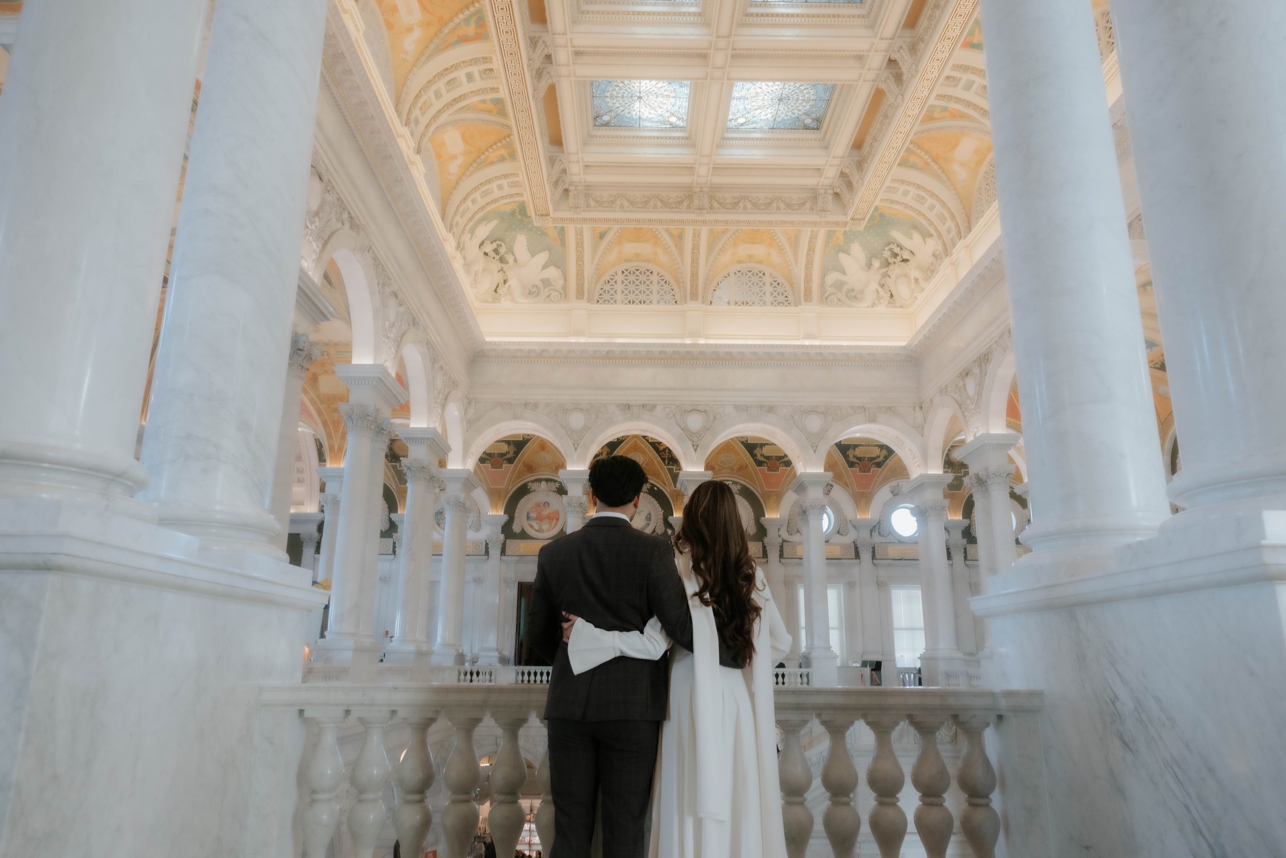 Couple observing the Grand Hall of the Library of Congress for a Washington DC engagement session.