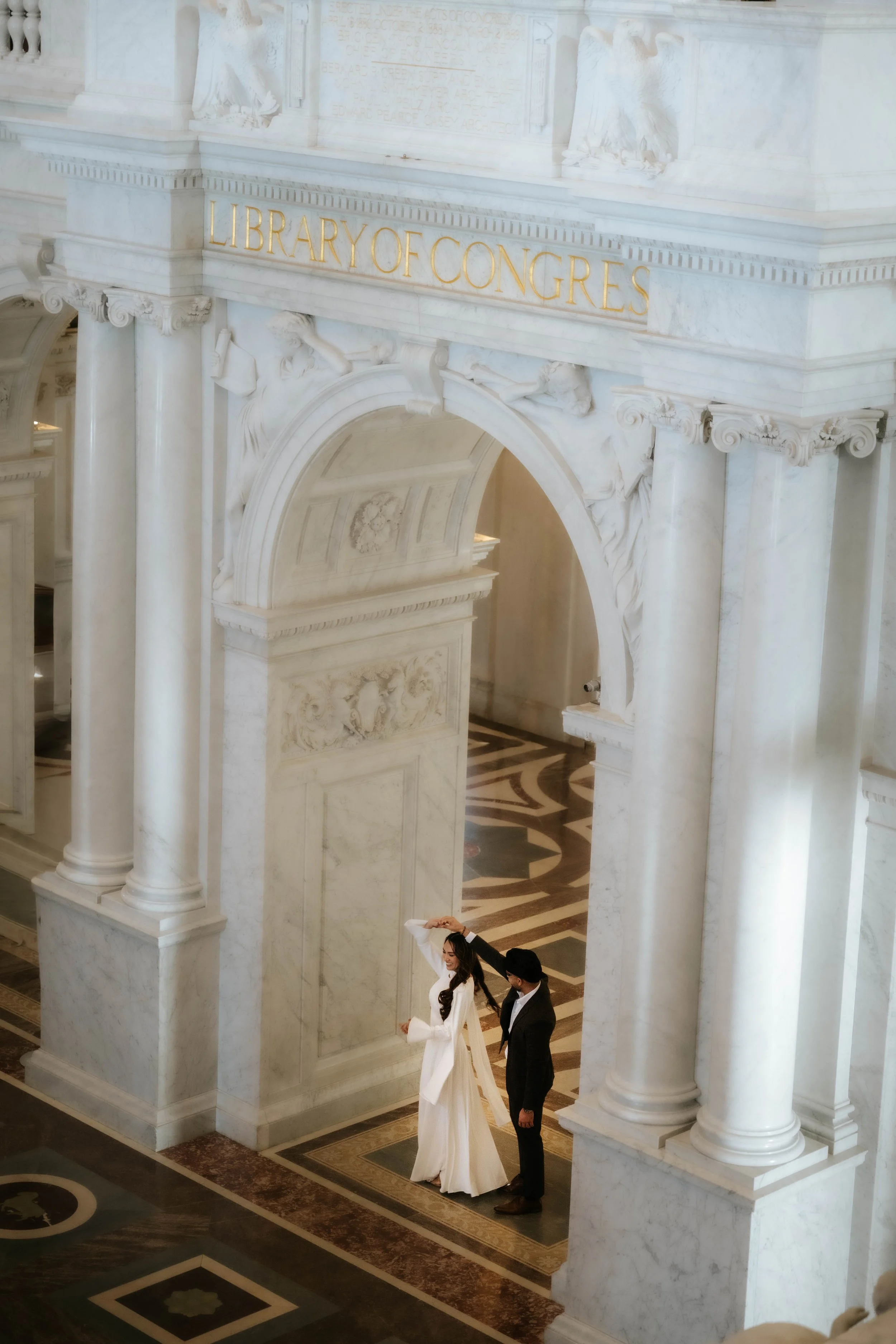 Wedding couple in elegant, classy, timeless attire at the Library of Congress for engagement photos. Photos taken by SnKWorks - Award Winning Photographer