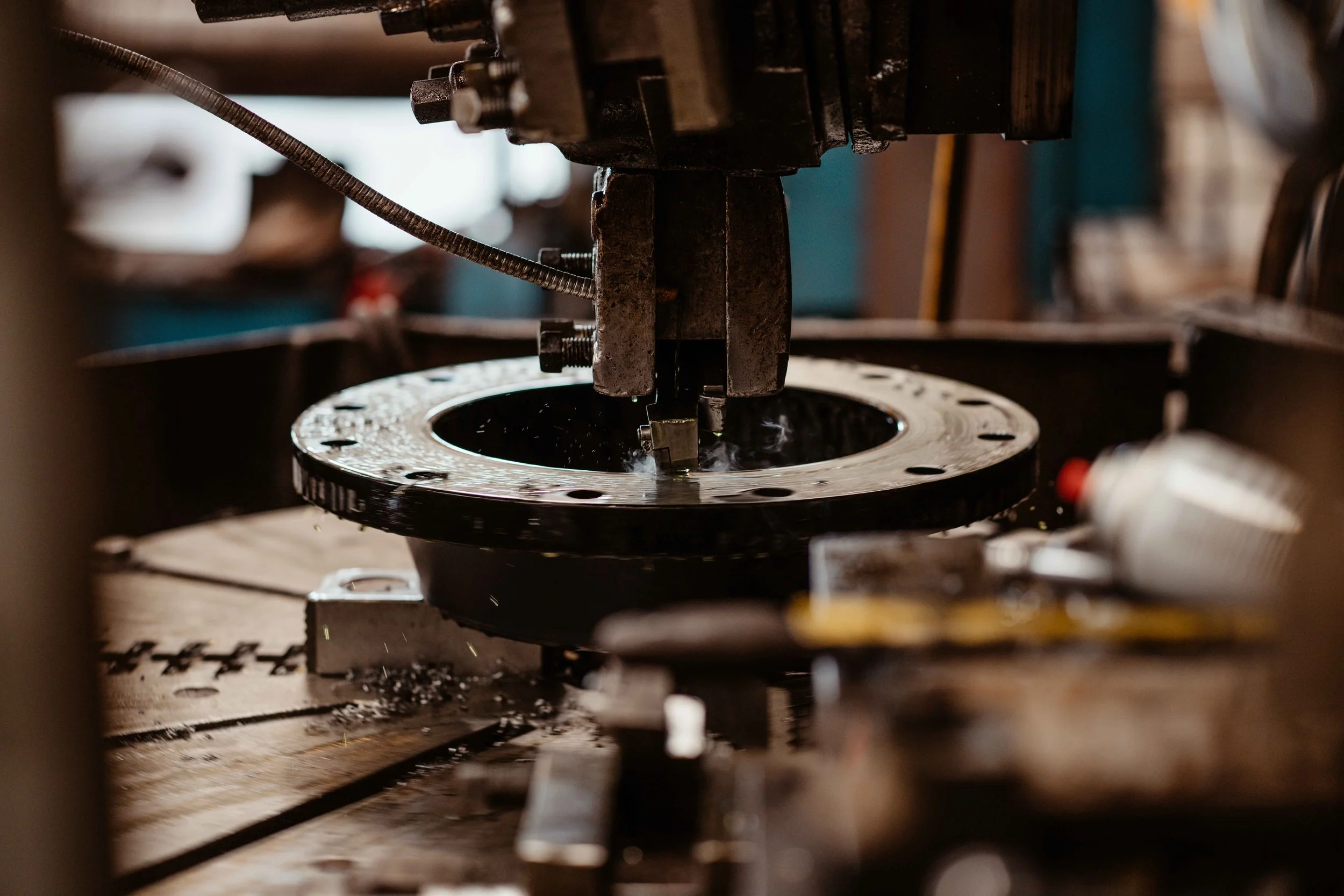 Close-up of industrial machinery in a workshop, with metal components and tools visible.