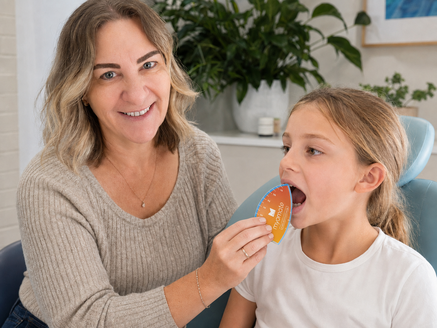Francesca Clarke measuring a child's mouth opening with a MyoMate during a tongue-tie assessment