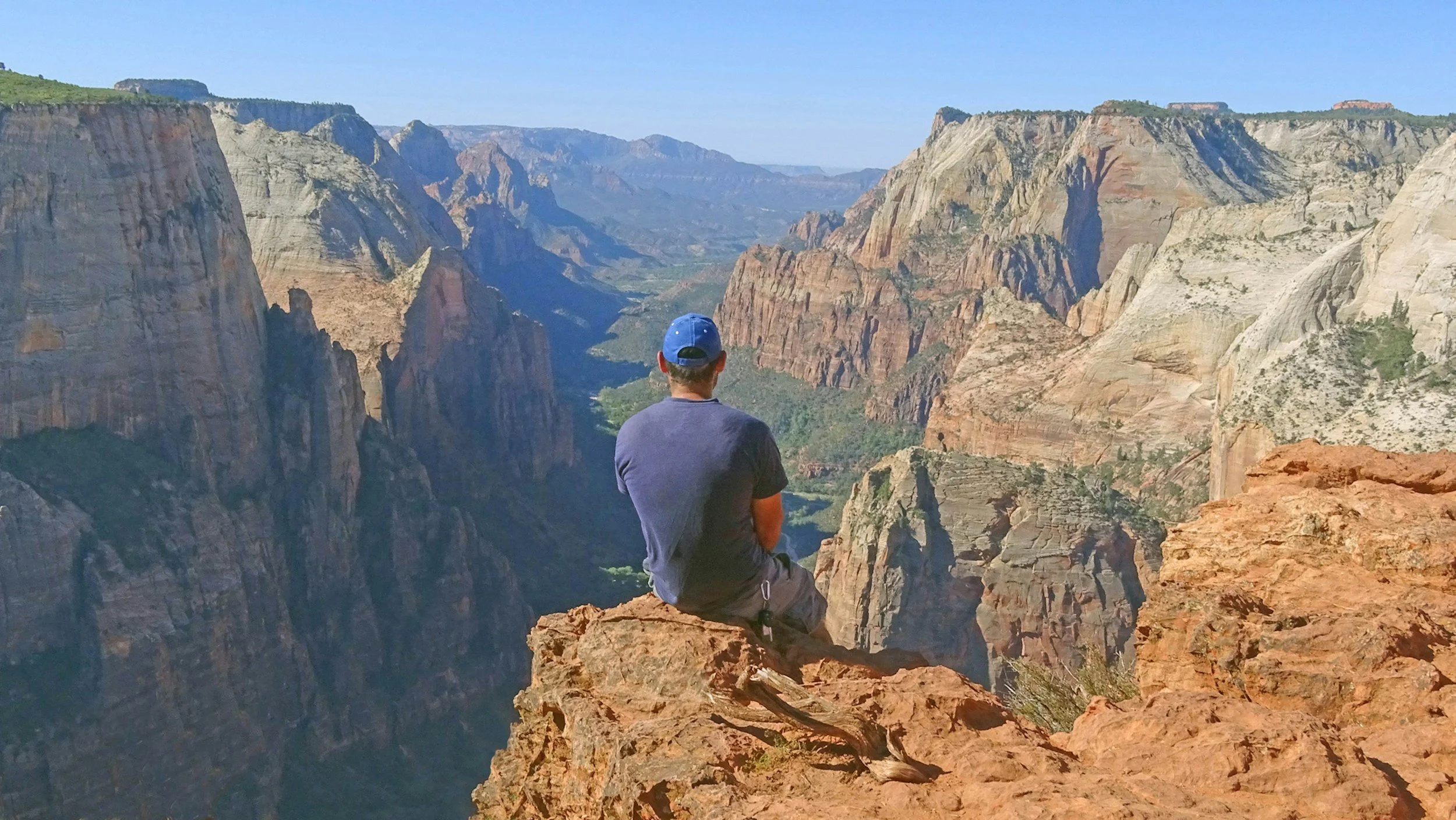 Man standing alone on a scenic overlook representing healthy boundaries, confidence, and emotional well-being after trauma.