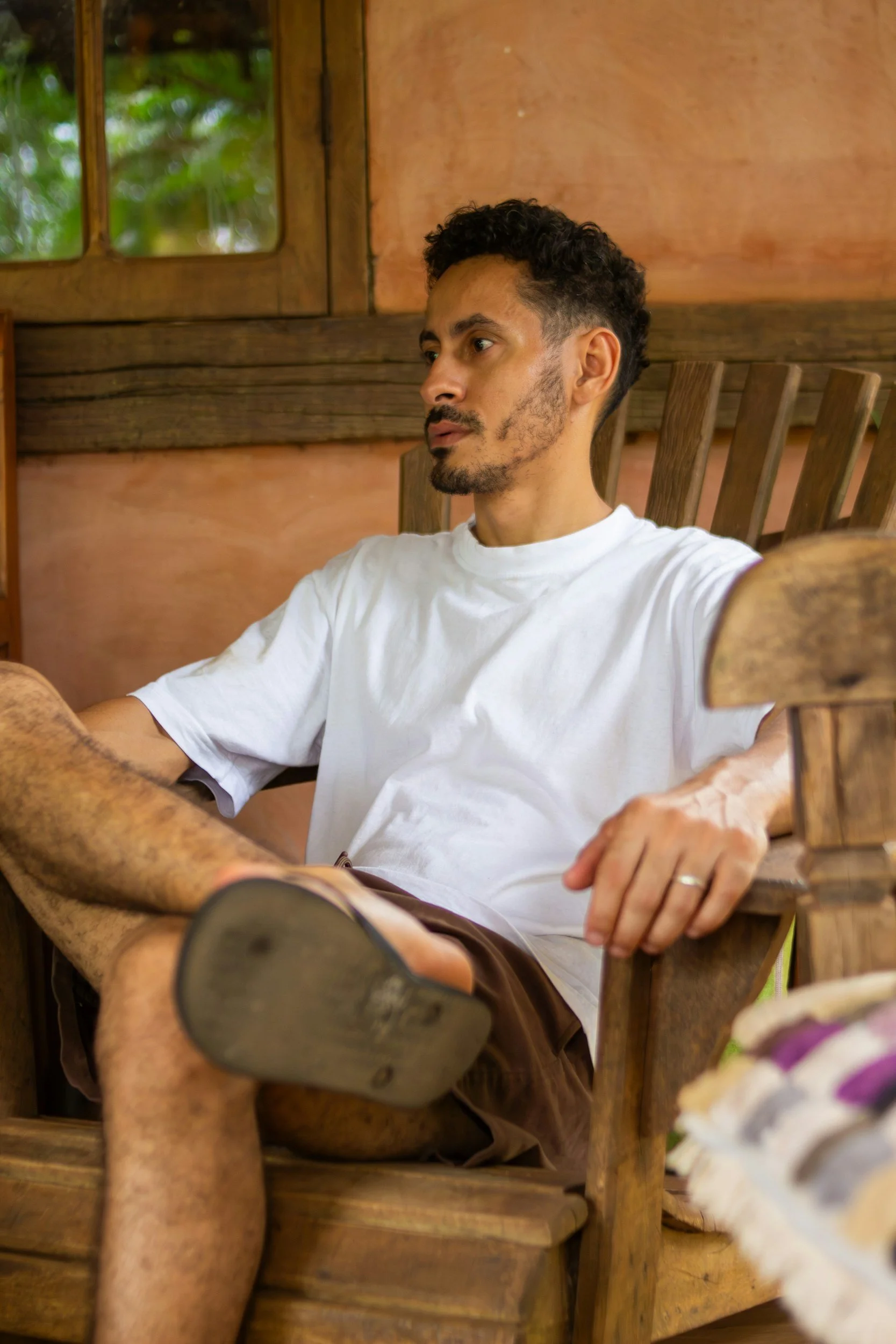 Man sitting quietly outdoors at sunset, appearing thoughtful as he struggles to relax after chronic stress or trauma.