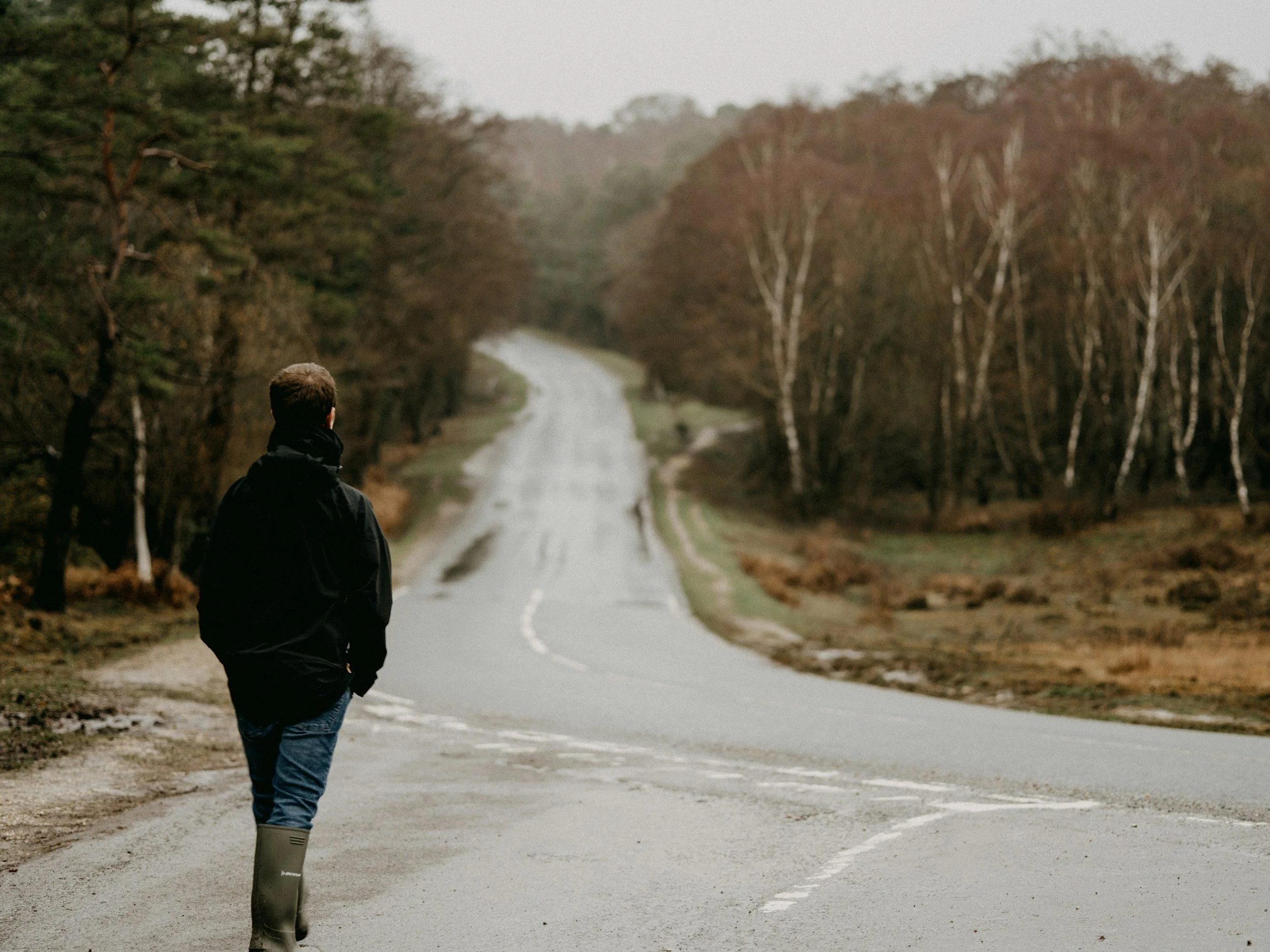 Man standing at a fork in the road, representing the process of choosing the right evidence-based trauma treatment.